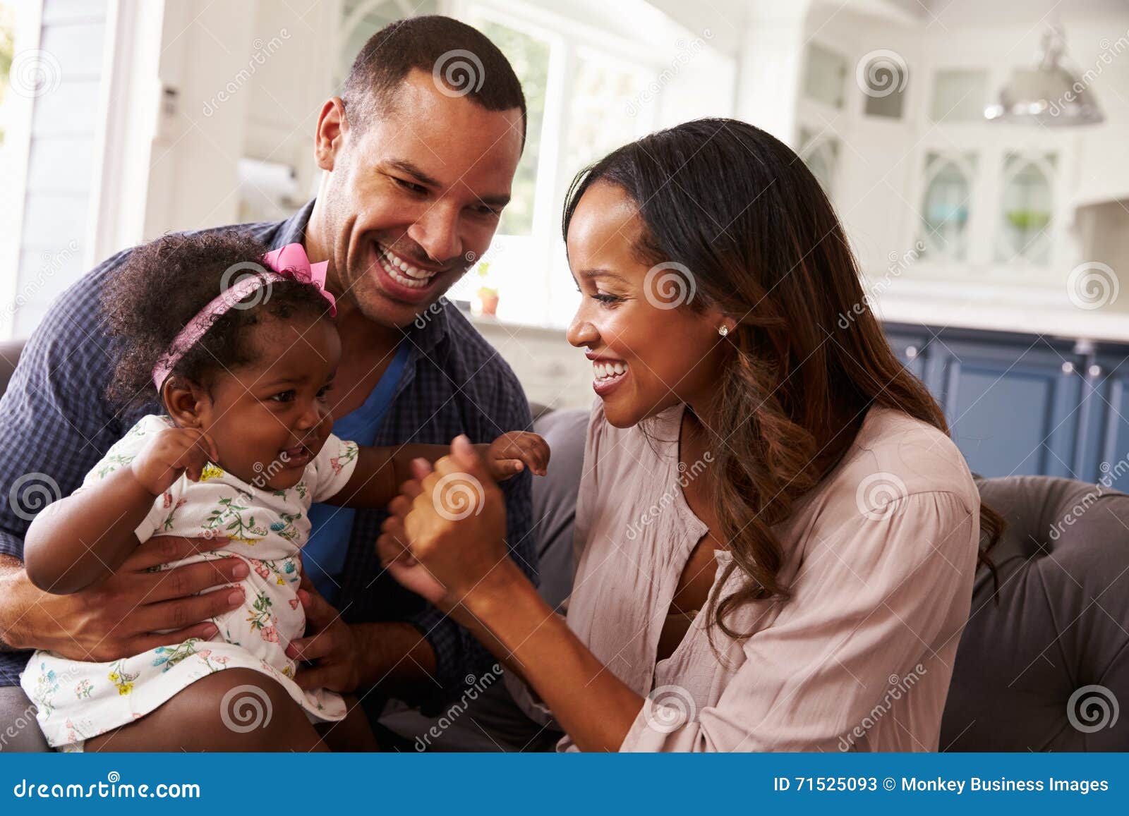 happy parents playing with baby girl on dadÃ¯Â¿Â½s knee, close-up