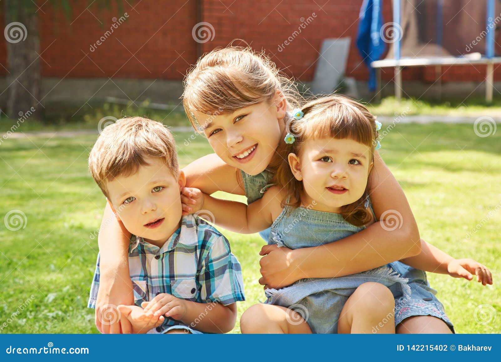 Happy Playful Children Outdoors in the Summer on Grass in a Backyard