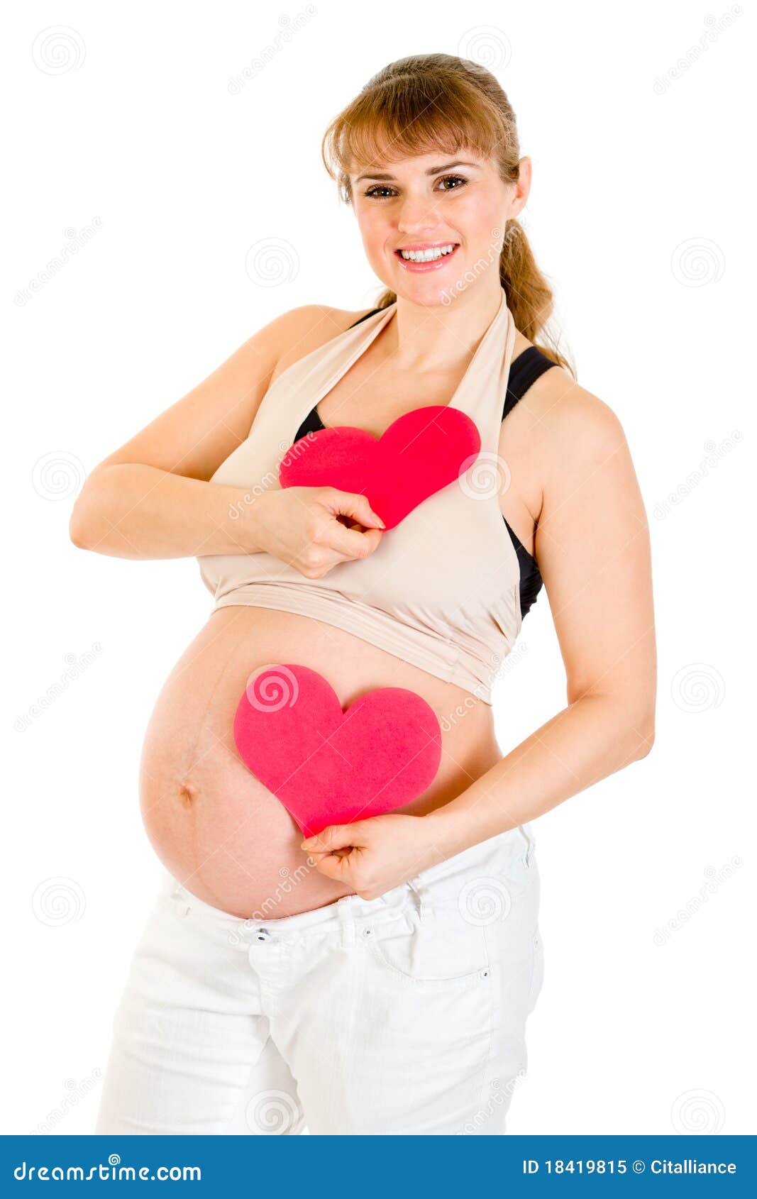 Happy pregnant woman holding two paper hearts in hands isolated on white. Concept - two hearts beating in unison.