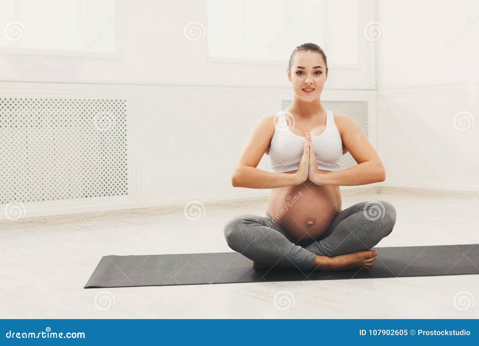 Cheerful girl sitting in lotus pose while stretching - a Royalty Free Stock  Photo from Photocase