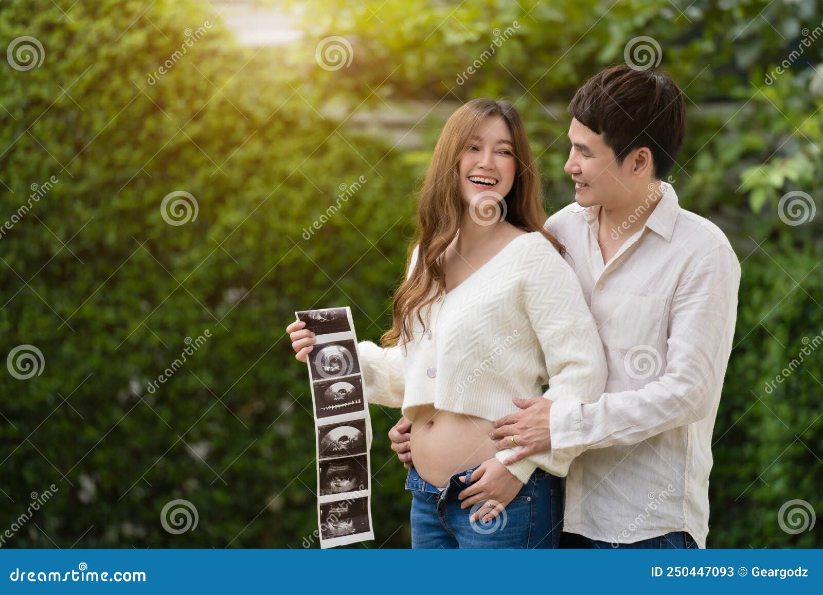 Happy Pregnant Woman and Her Husband Looking Ultrasound Scan Photo