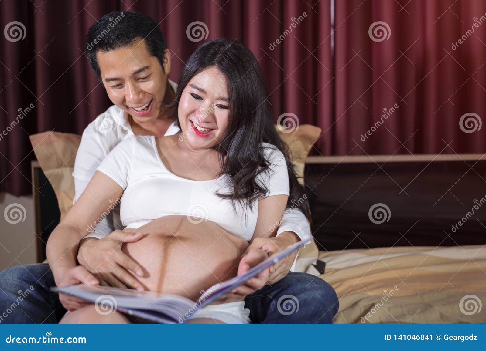 Happy Pregnant Woman and Her Husband Looking Ultrasound Scan Photo Album on  Bed Stock Image - Image of expecting, background: 141046041