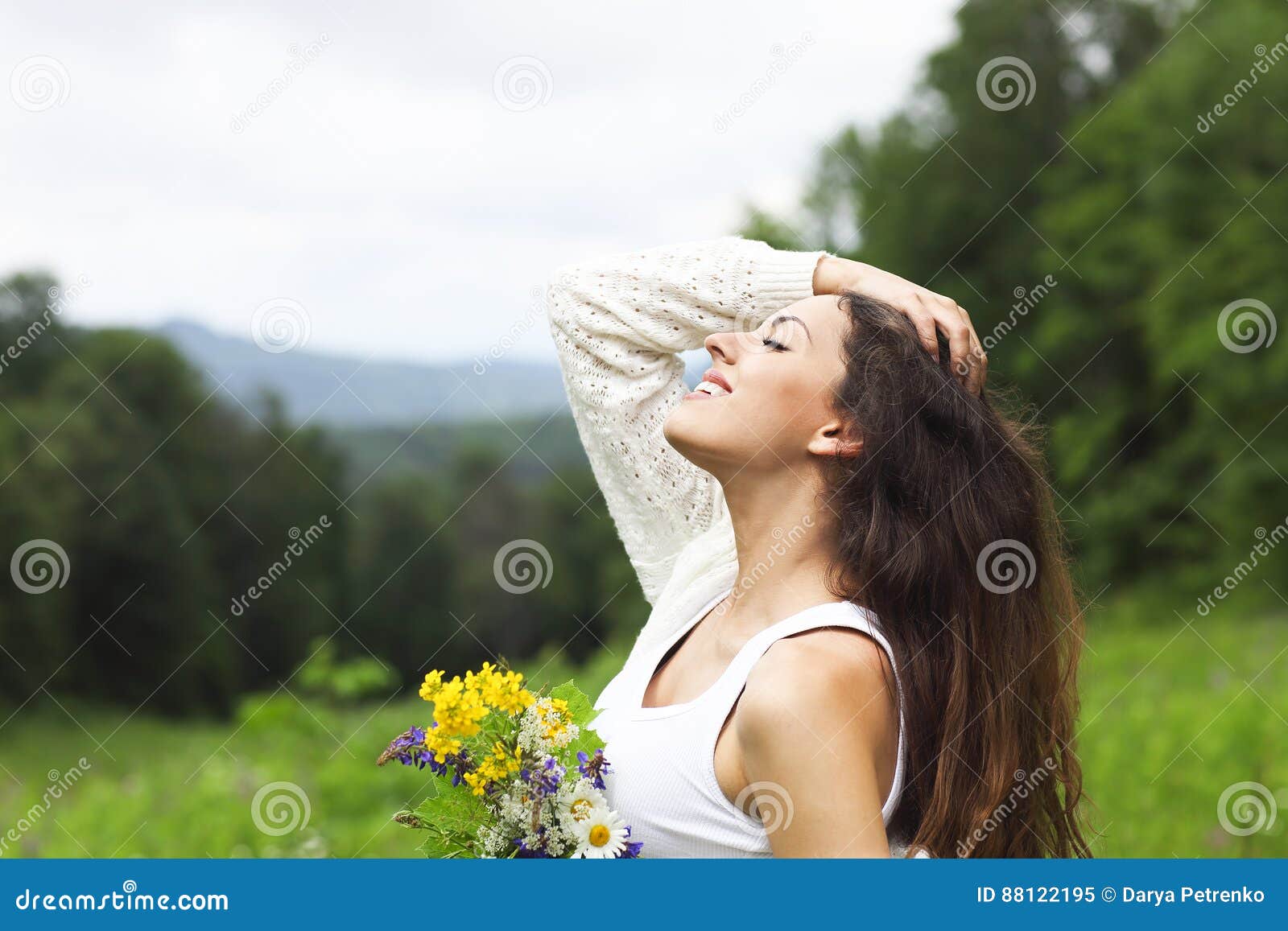 happy pretty brunette woman in chamomile field