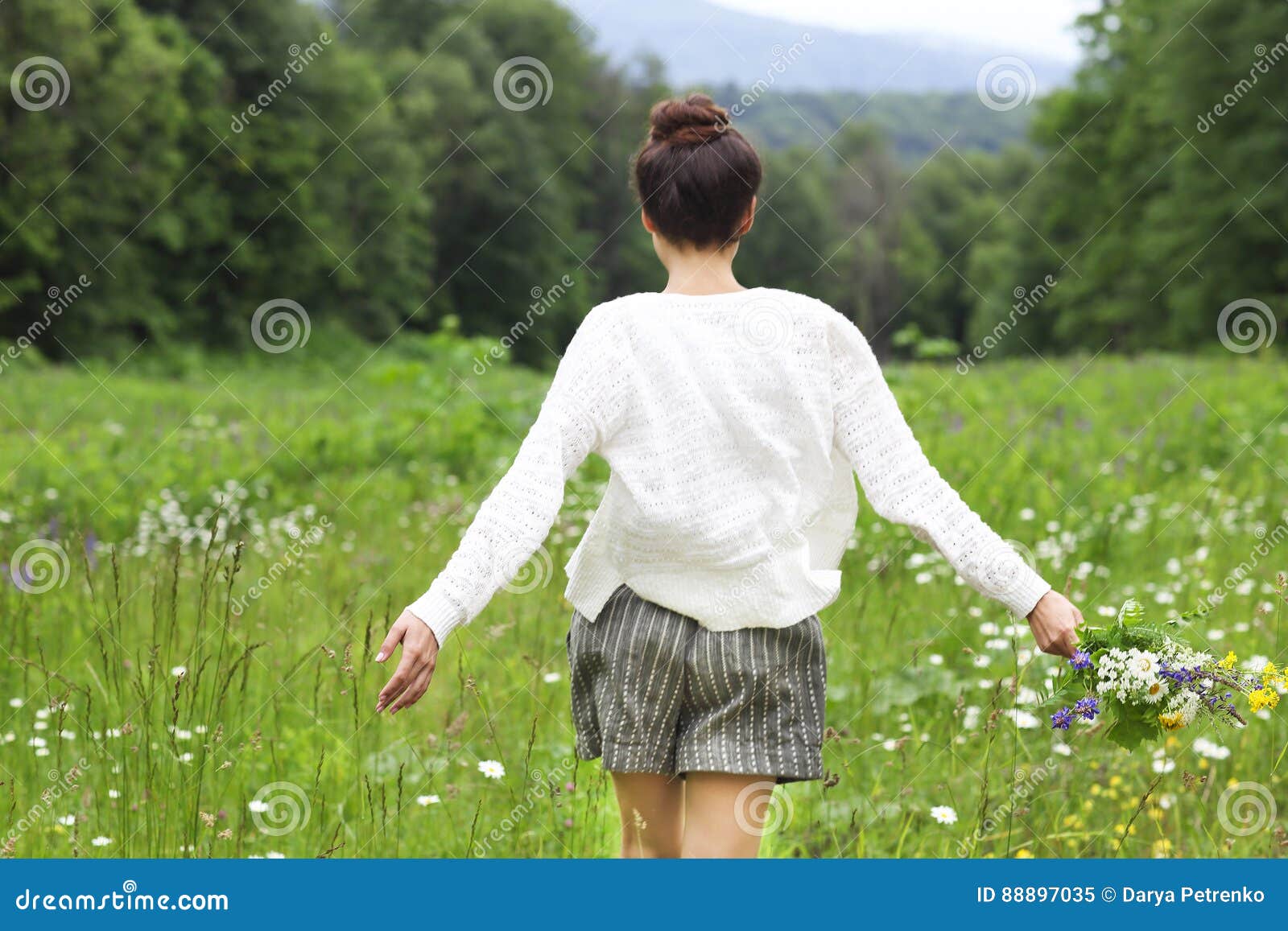 happy pretty brunette woman in chamomile field