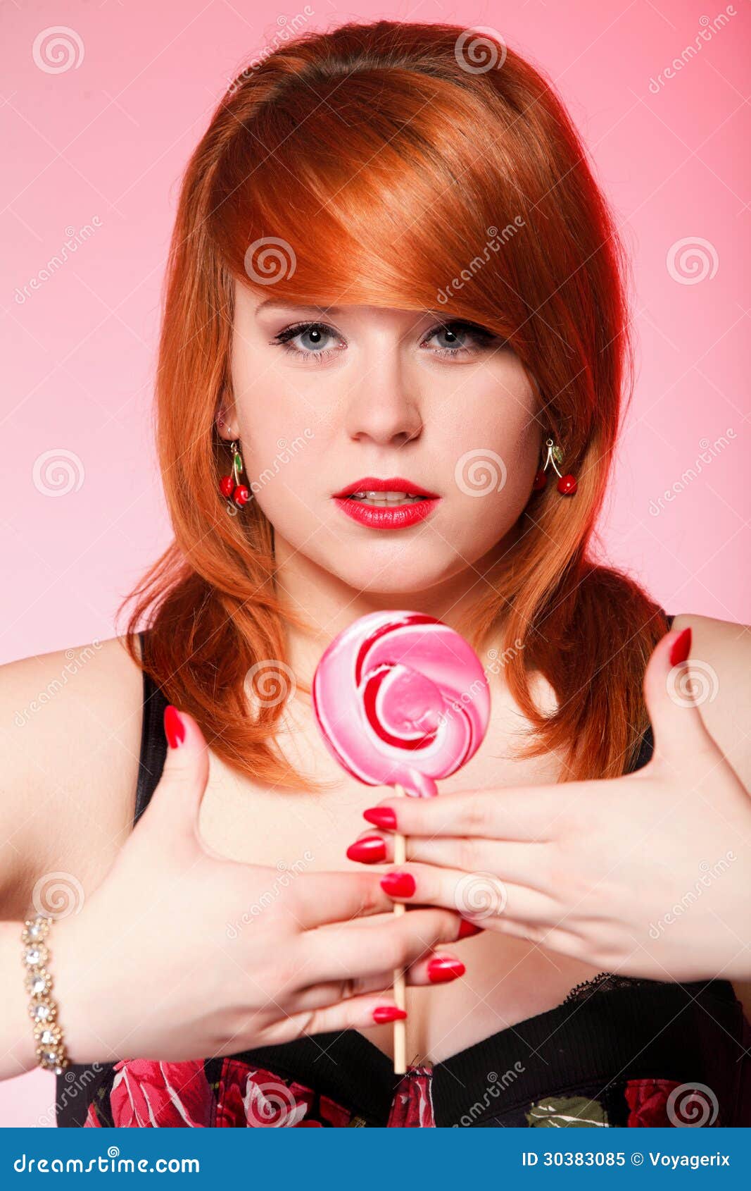 Happy redhair woman with lollipop candy. Happy young redhair woman with lollipop candy pink background