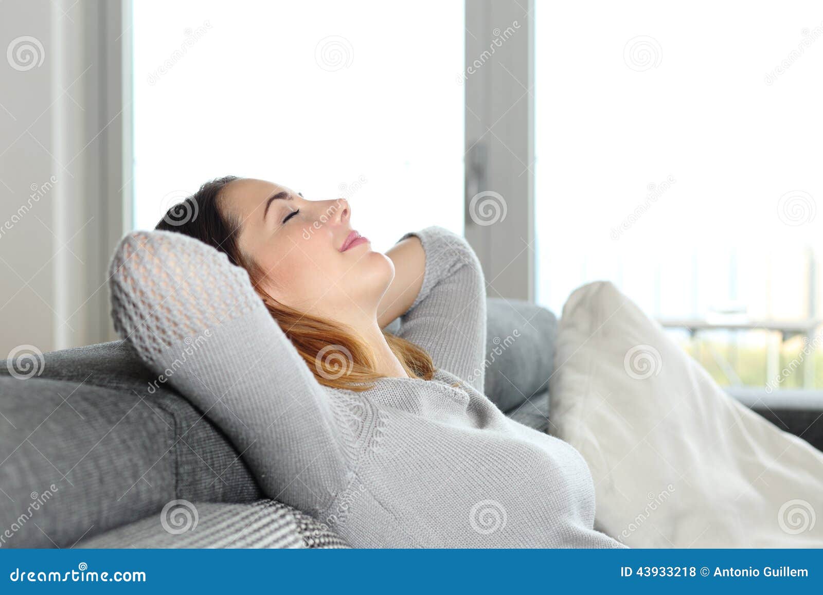 happy relaxed woman resting on a couch at home