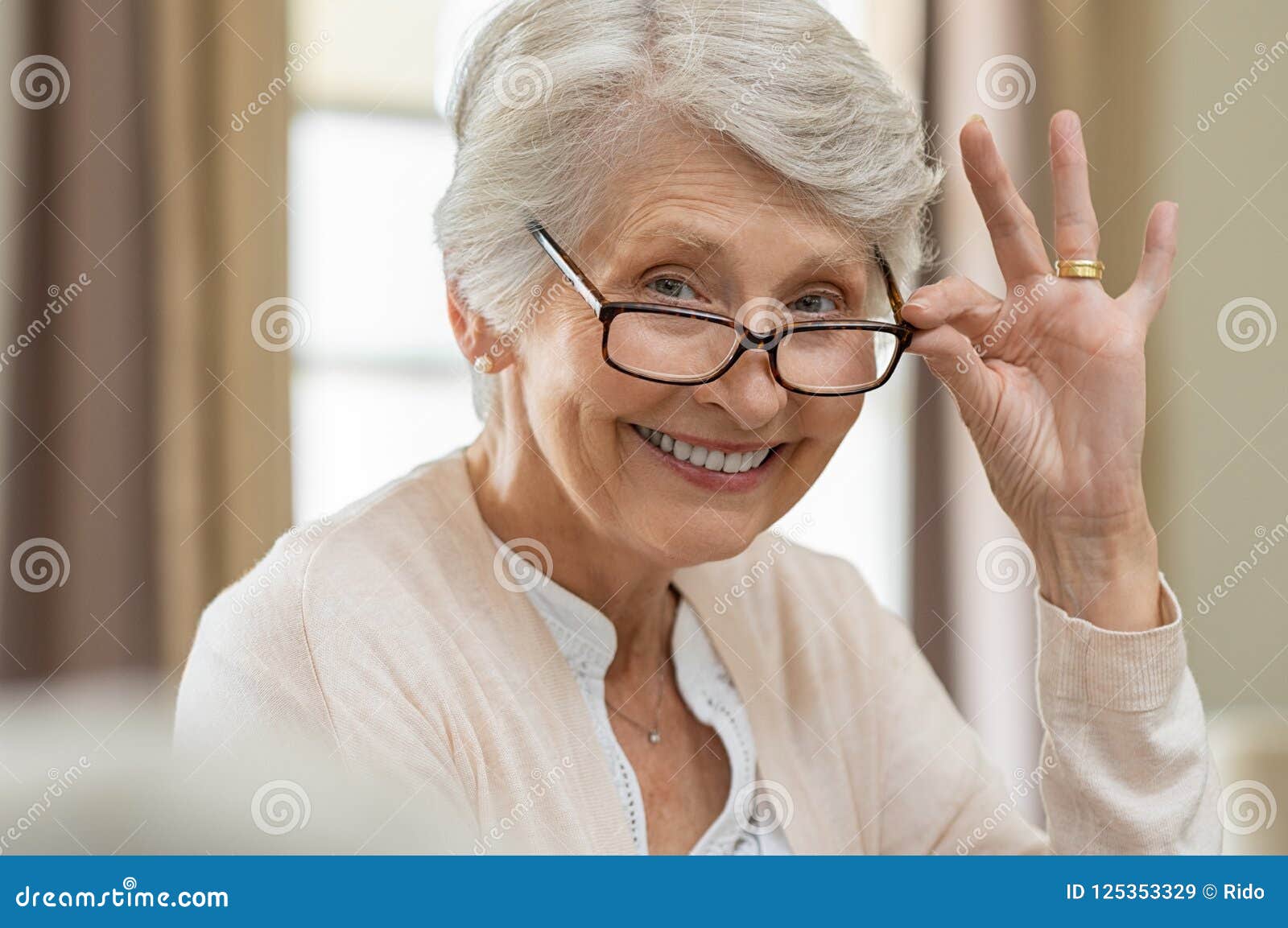 senior woman holding eyeglasses