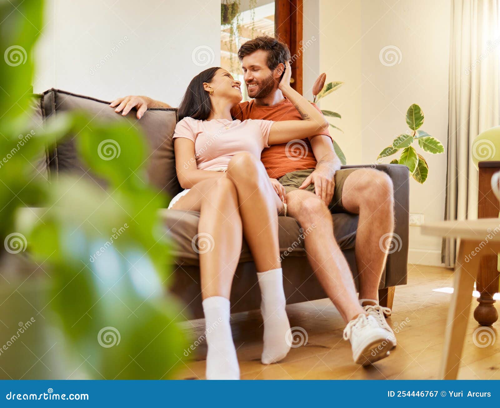 Happy, Romance and Couple Relax Indoors Together, Bonding and Talking on Sofa Together image
