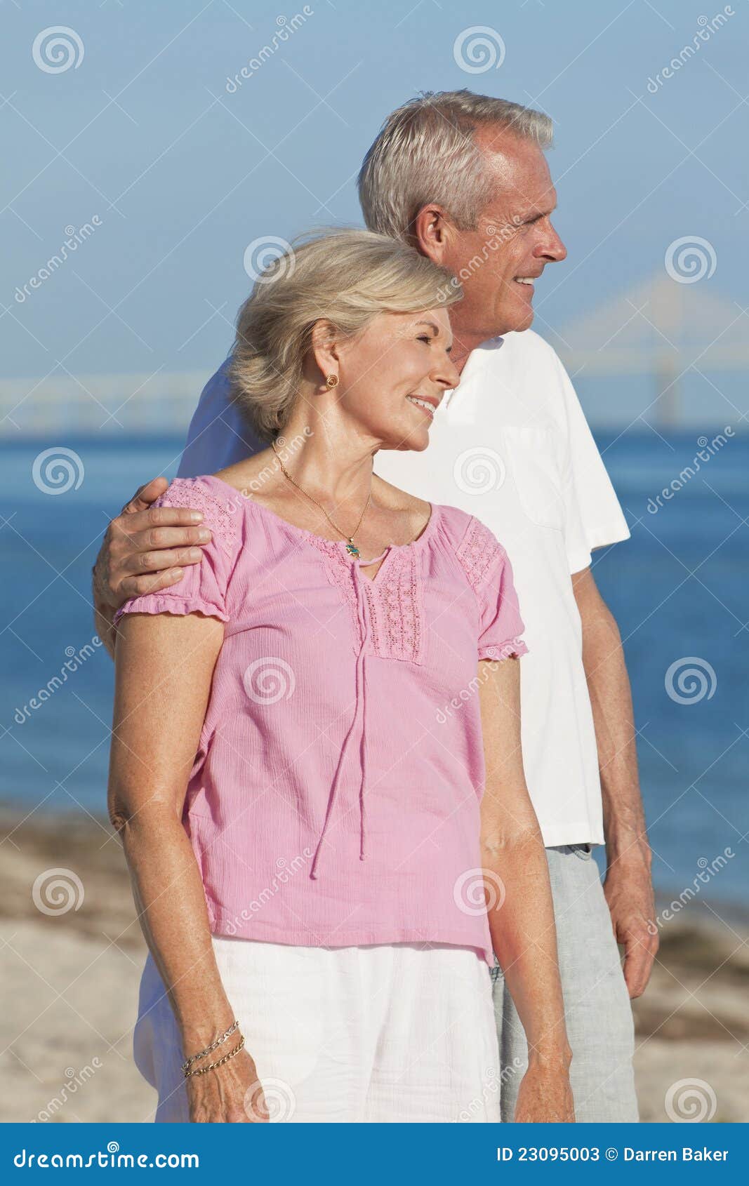 happy romantic senior couple embracing on beach