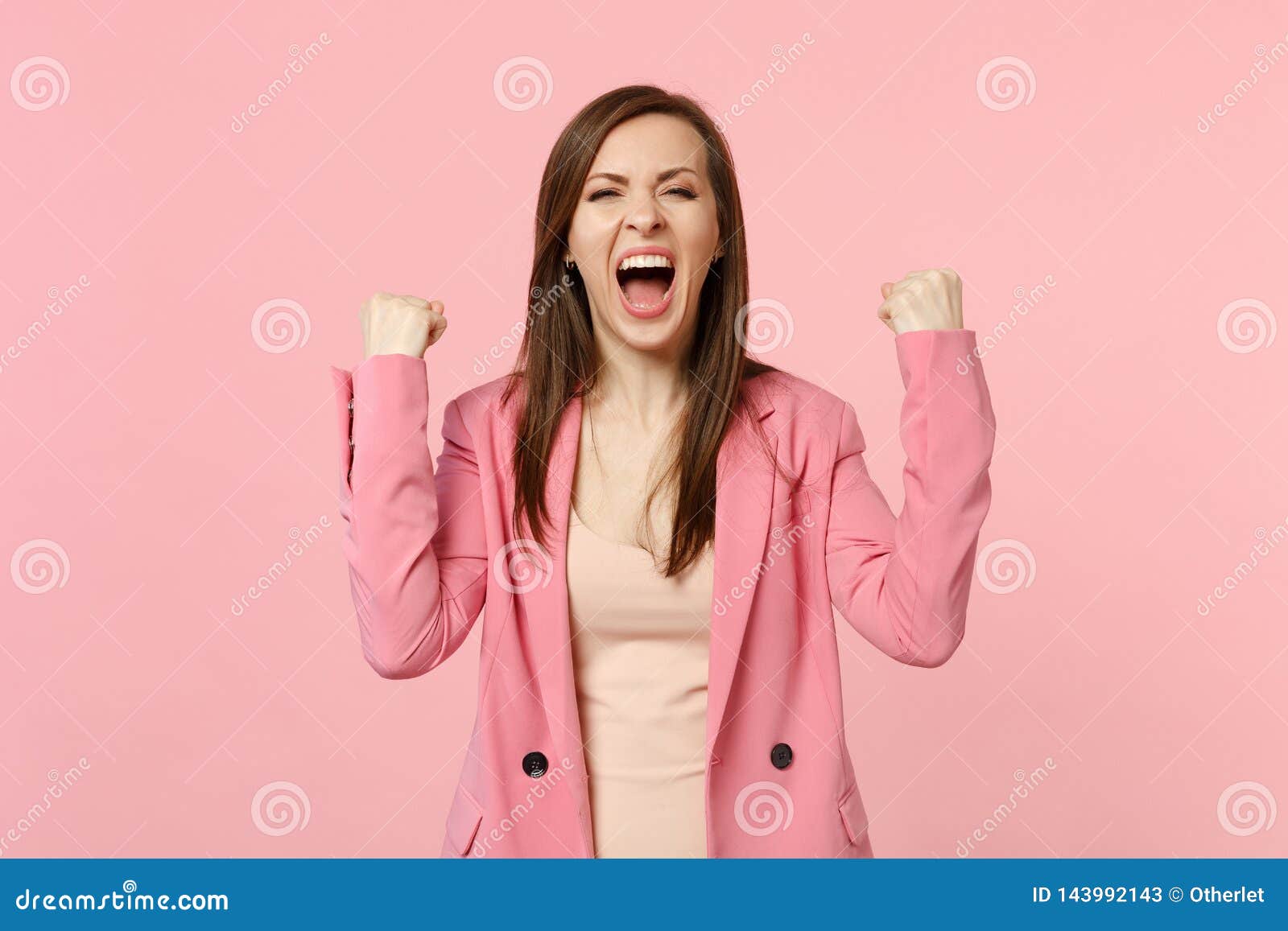 happy screaming young woman in jacket clenching fists like winner expressive gesticulating with hands  on pastel