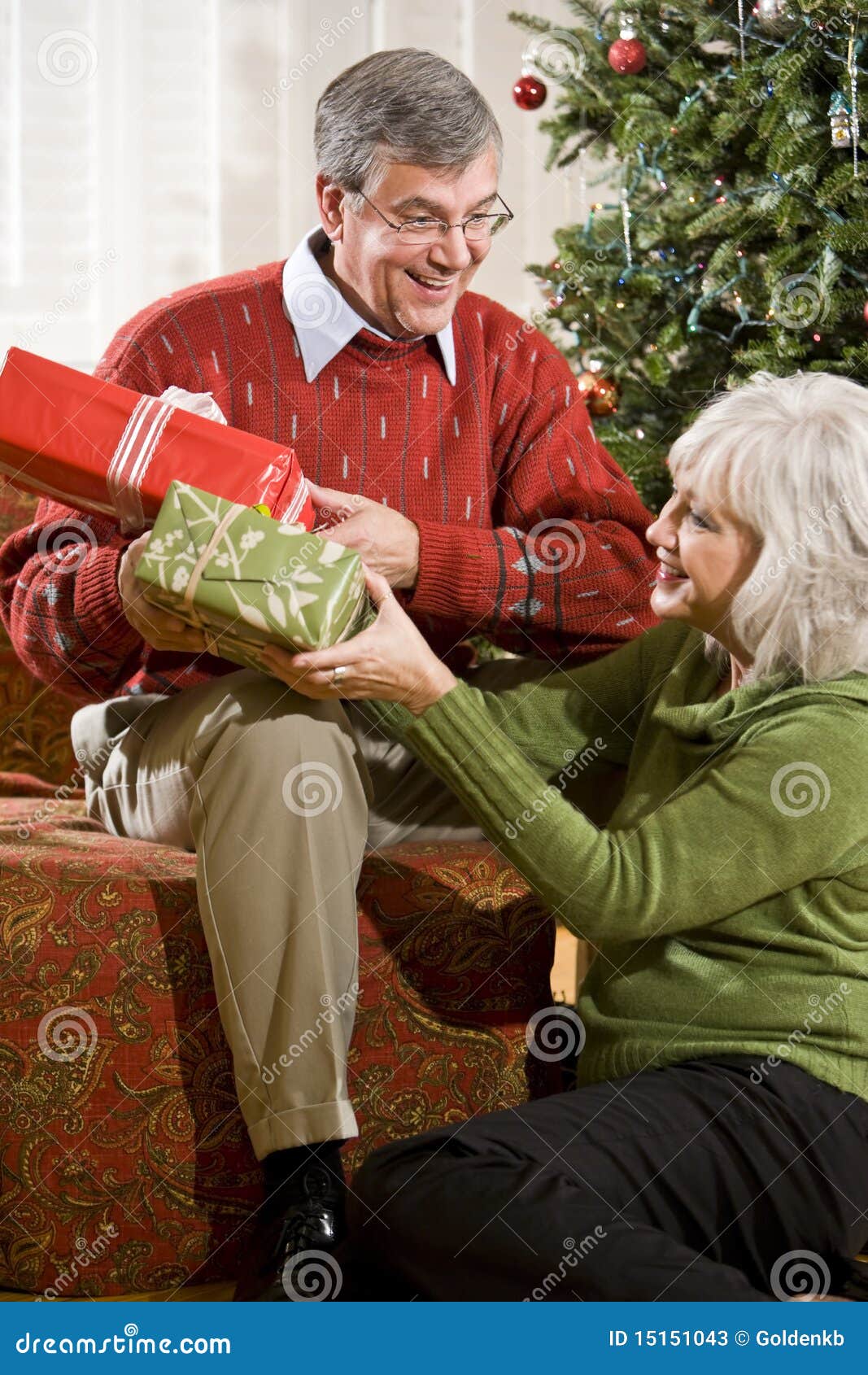 happy senior couple exchanging christmas gifts