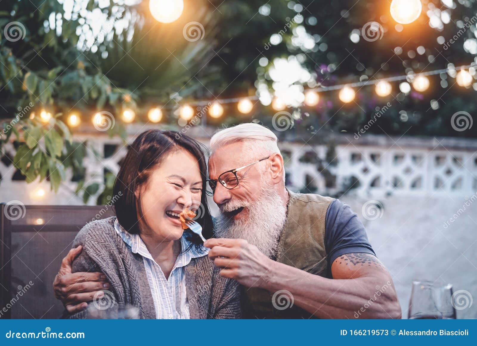 happy senior couple having fun at dinner house party