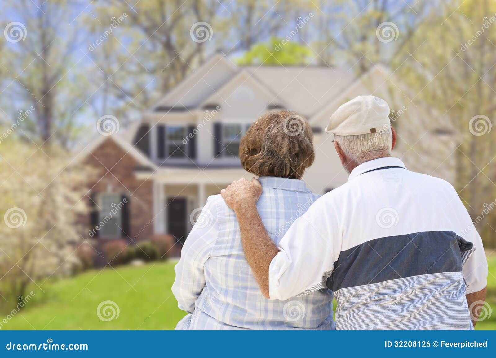 happy senior couple looking at front of house