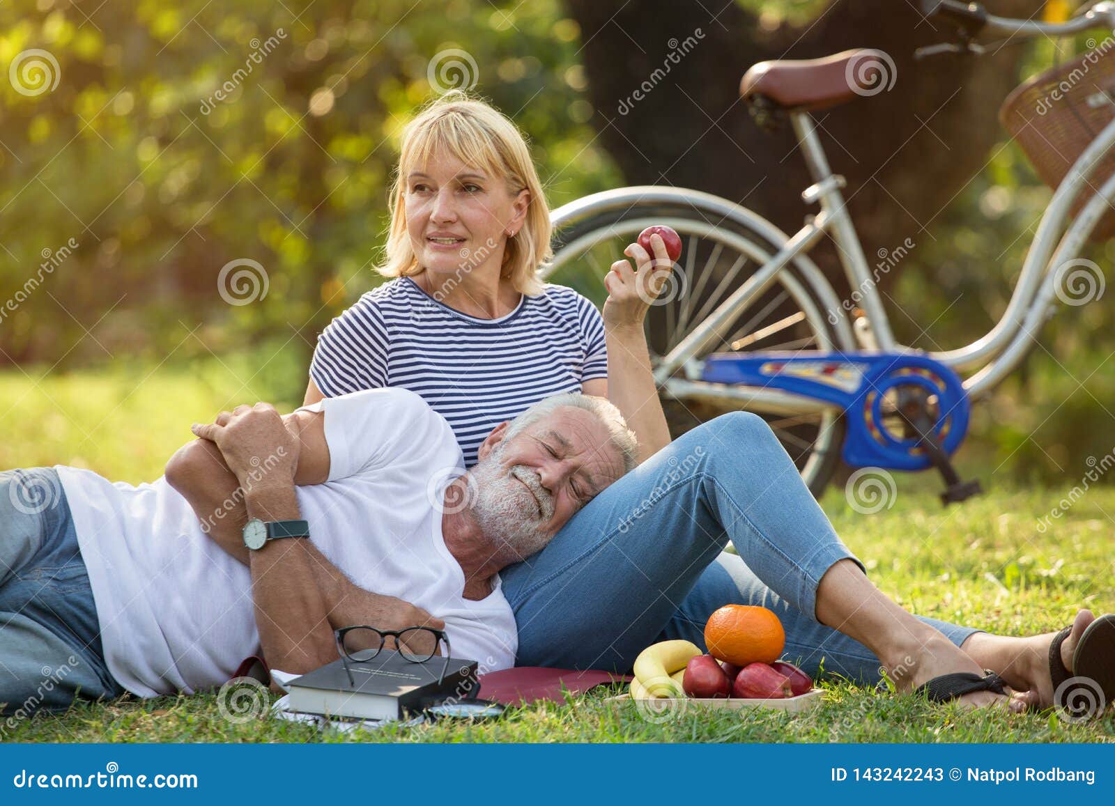 happy senior couple relaxing in park  together. old people sitting on grass in the summer park . elderly resting .mature