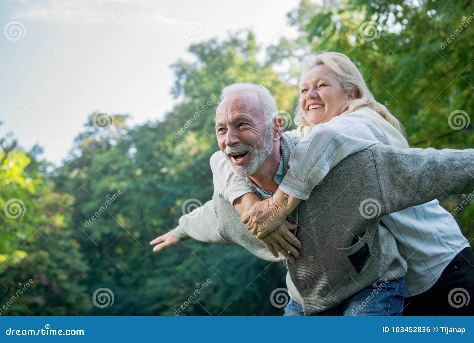 happy senior couple smiling outdoors in nature