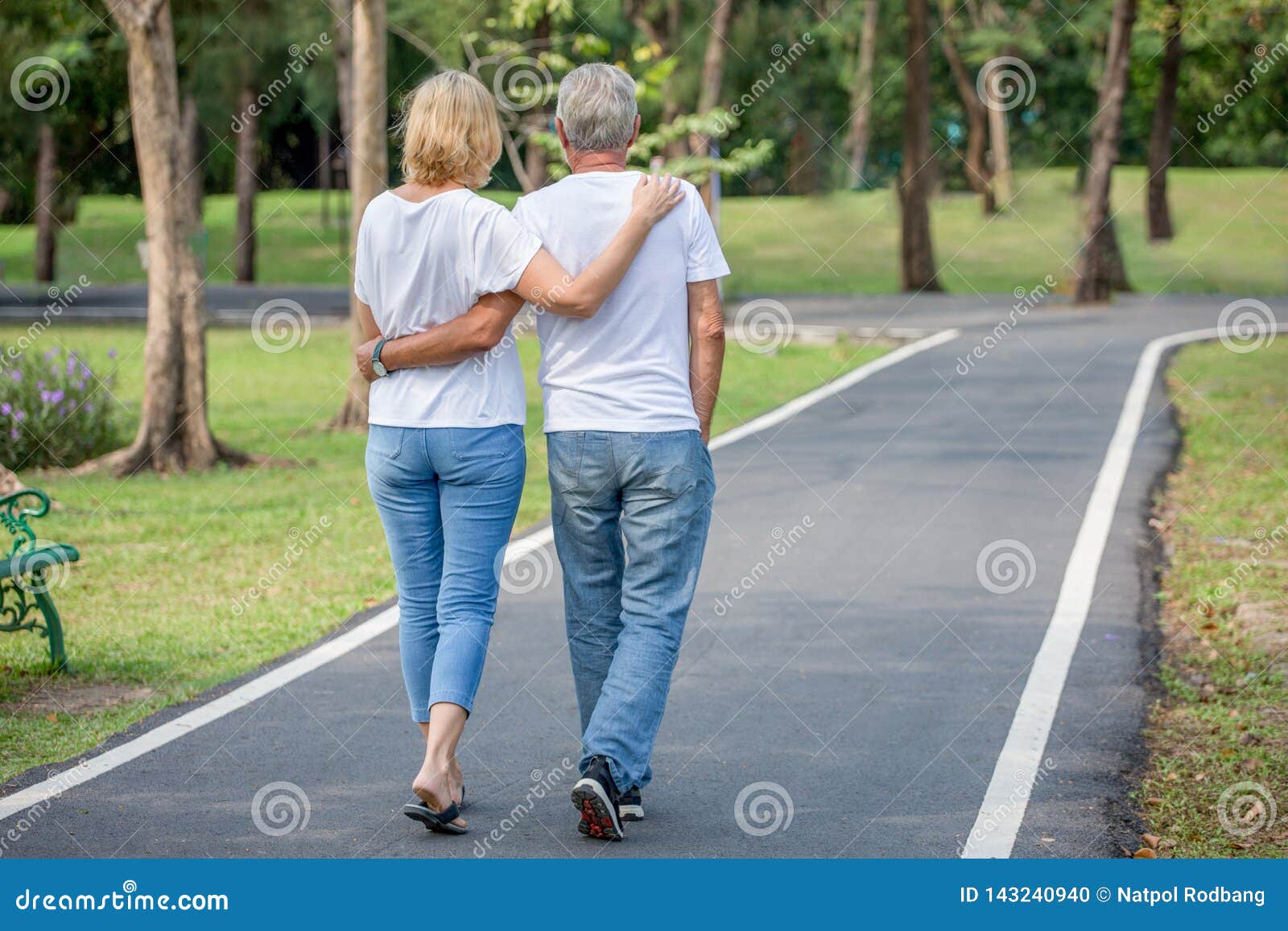 happy senior loving couple relaxing at park embracing and walking together in morning time. old people  hugging and enjoying