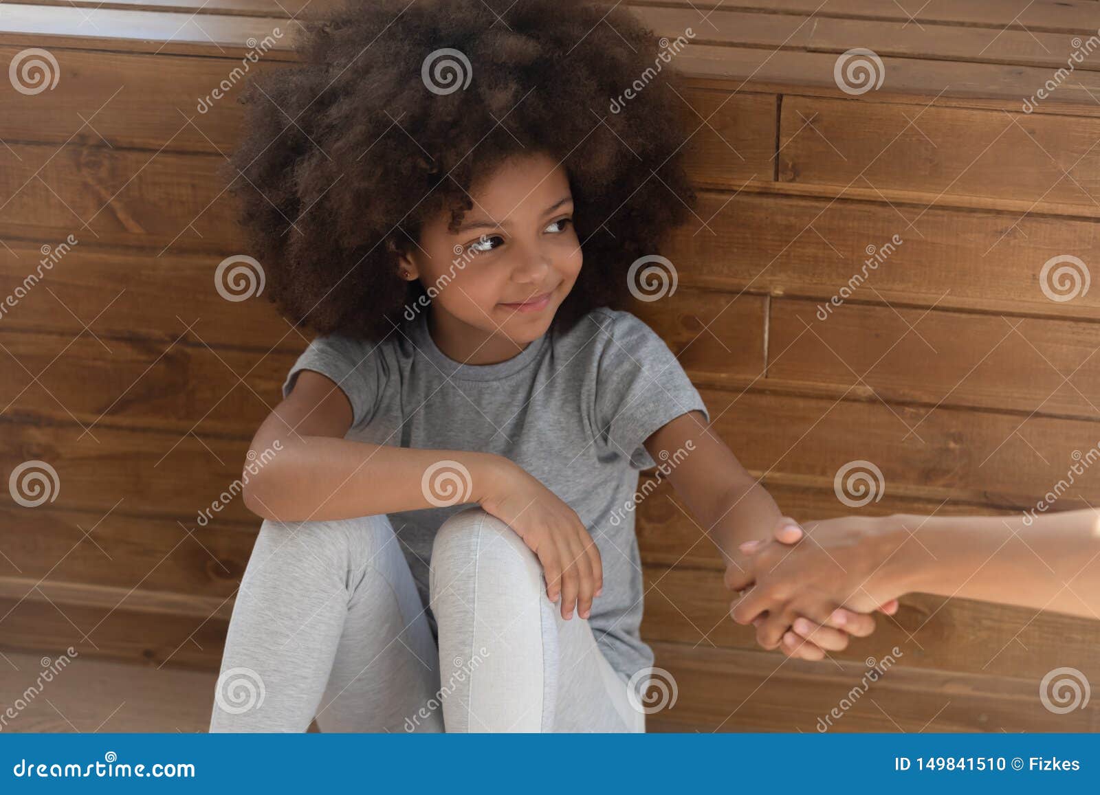 happy small kid girl orphan holding hand of foster parent