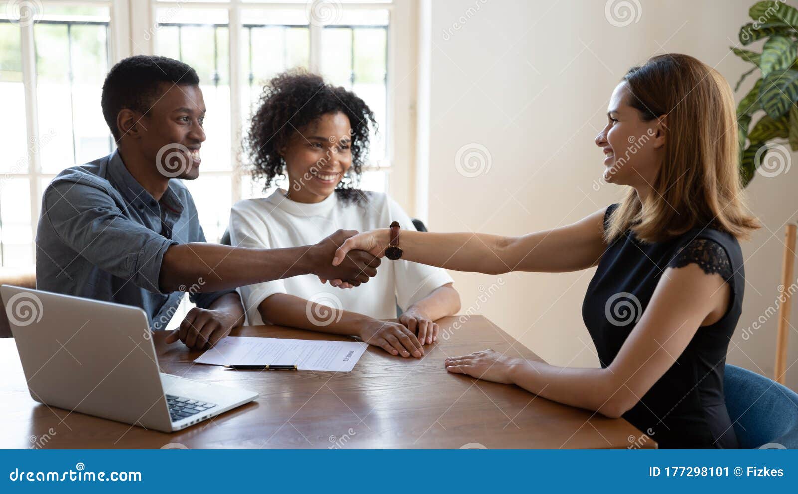 happy african married couple shake hands to mortgage insurance broker