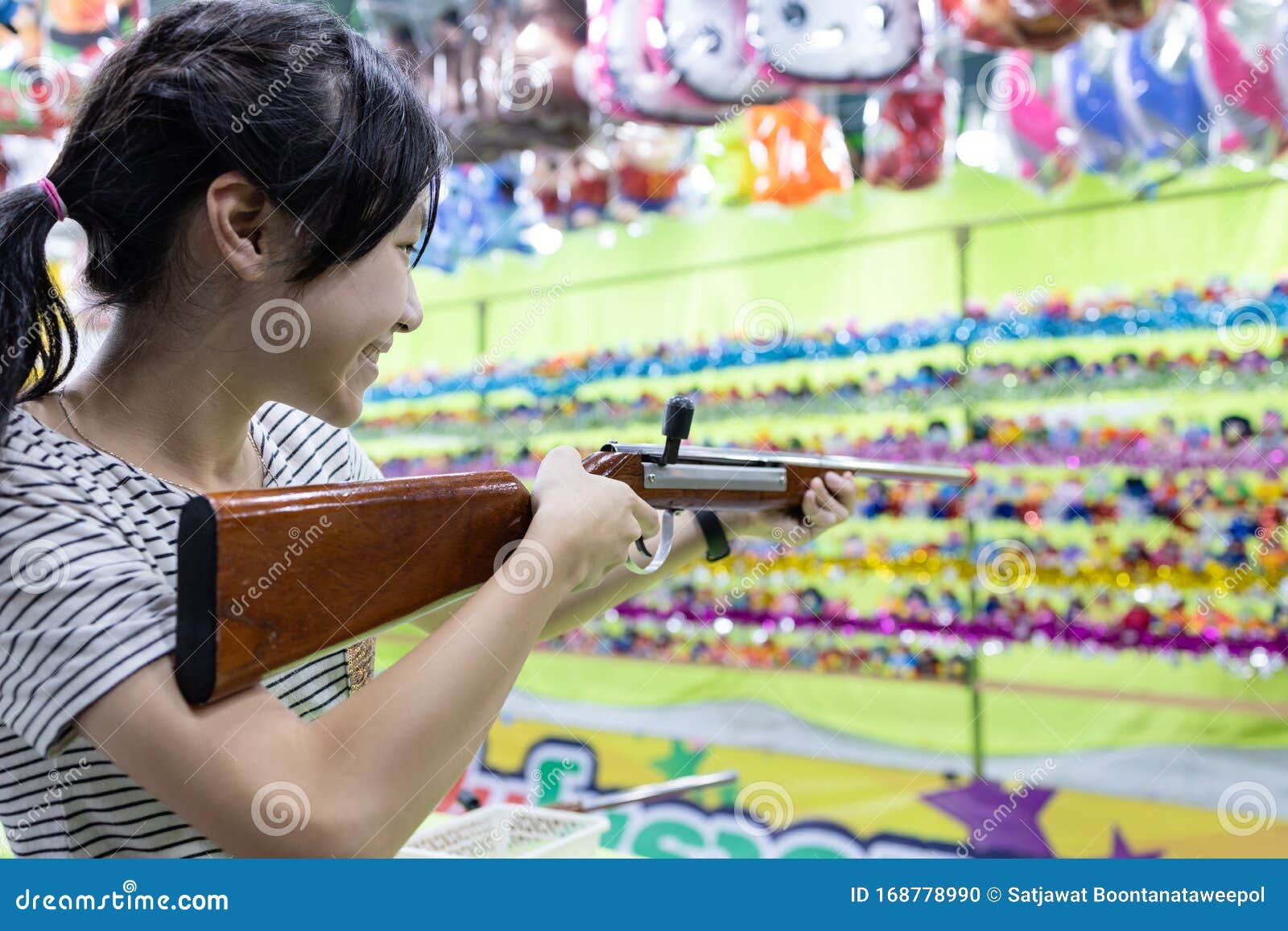 Happy Smiling Asian Child Girl Holding Wooden Gun,aim To the Point,shooting the Target,female Playing Shooting Games for a Stock Photo