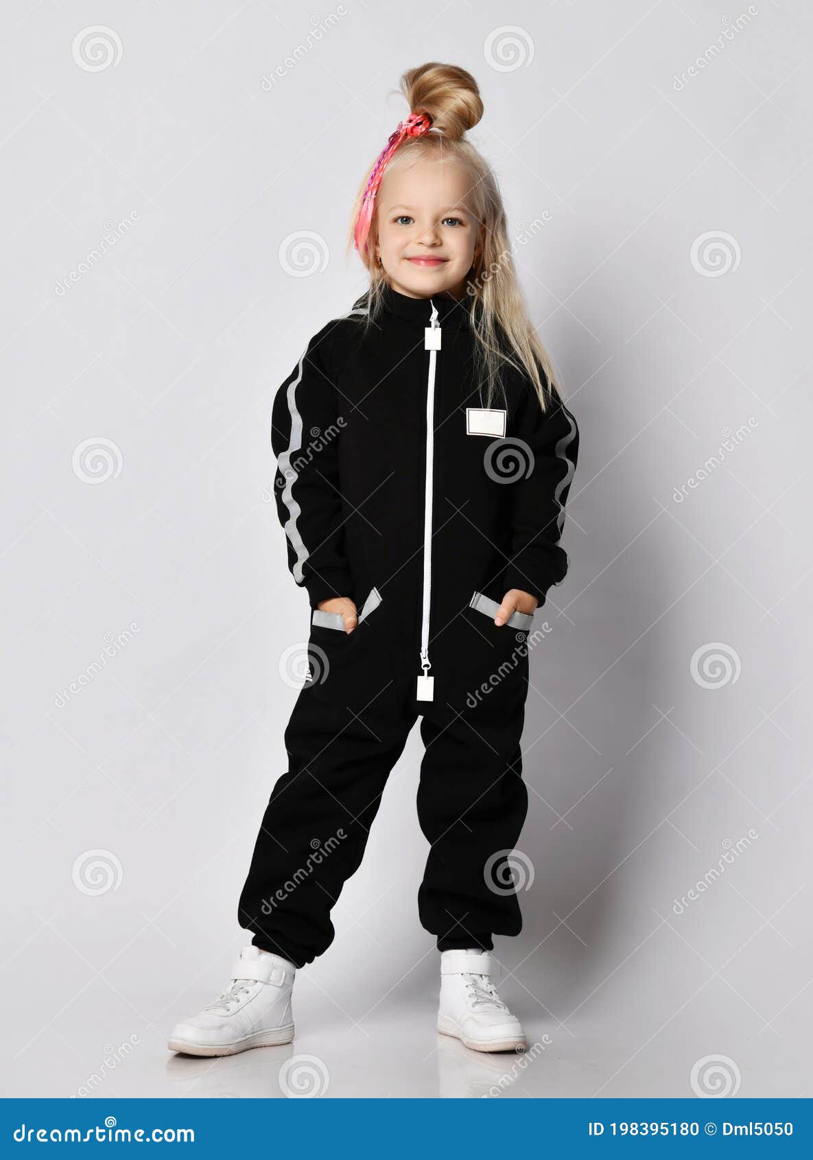 Happy Blonde Kid Girl with Modern Hairstyle in Black Jumpsuit and Sneakers  Stands Still Posing with Her Hands in Pockets Stock Photo - Image of  daughter, girl: 198395180