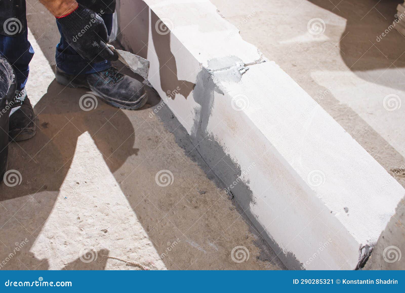 happy smiling construction worker constructing or building wall by placing bricks and cement - concept of hard working, manual