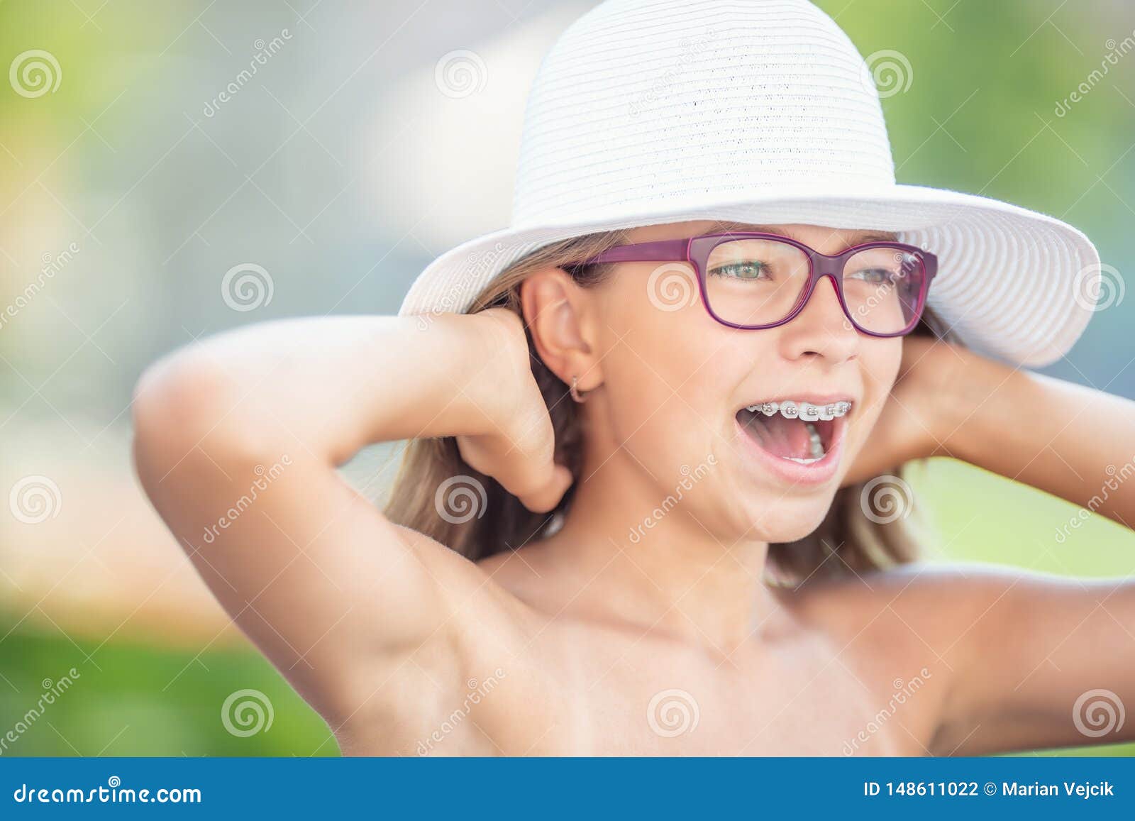 happy smiling girl with dental braces and glasses.  orthodontist and dentist concept