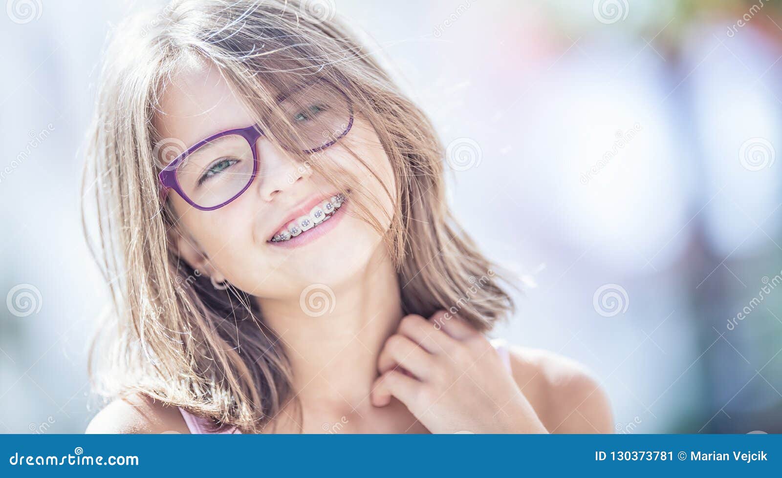 happy smiling girl with dental braces and glasses. young cute ca