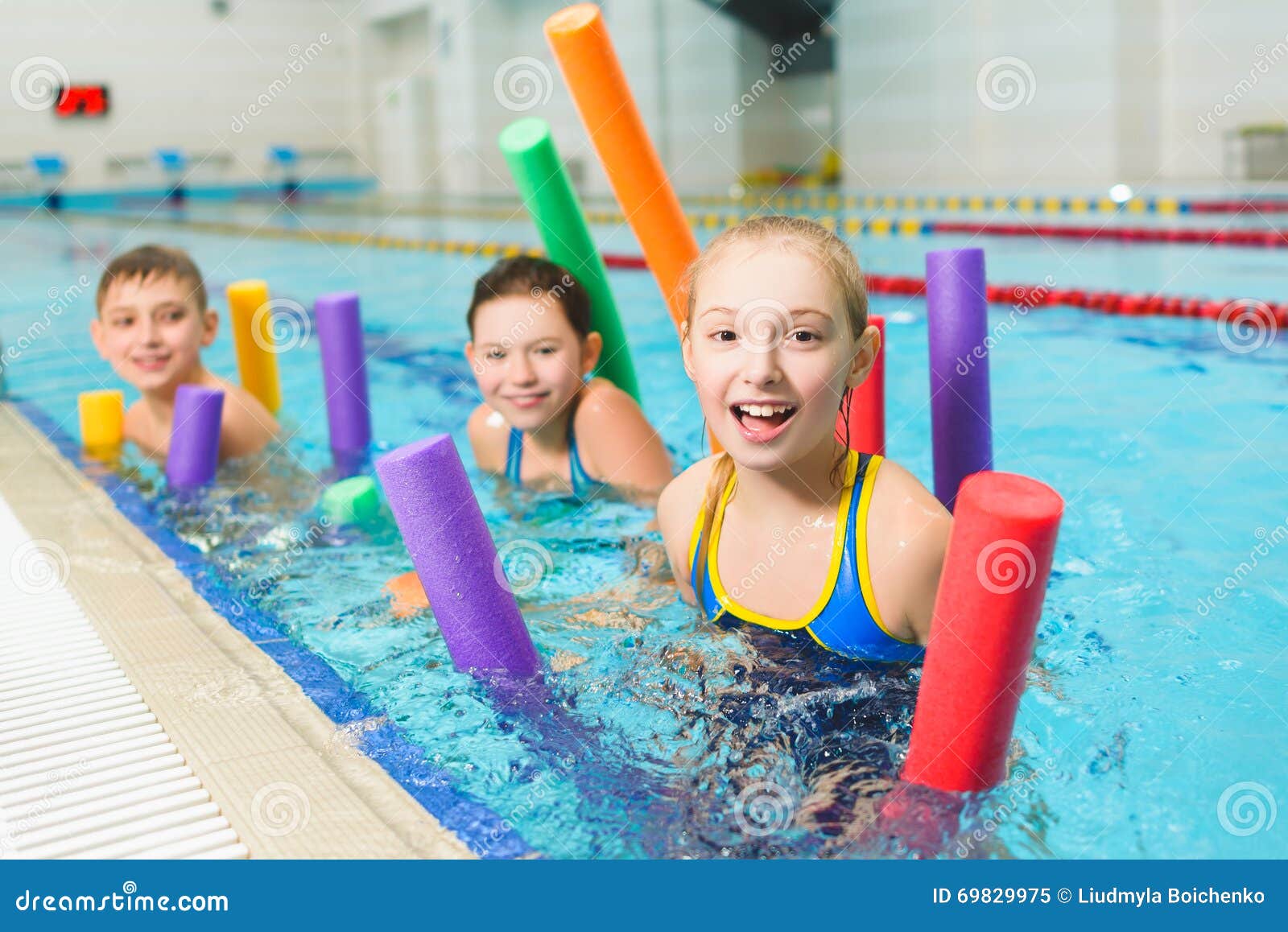 Happy and Smiling Group of Children Learning To Swim with Pool Noodle