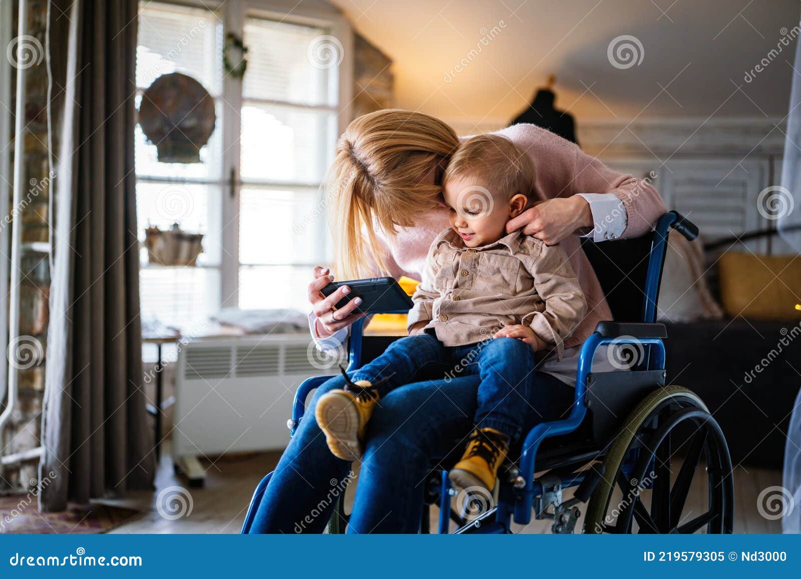 Happy Smiling Mother With Disability In Wheelchair Playing With Child