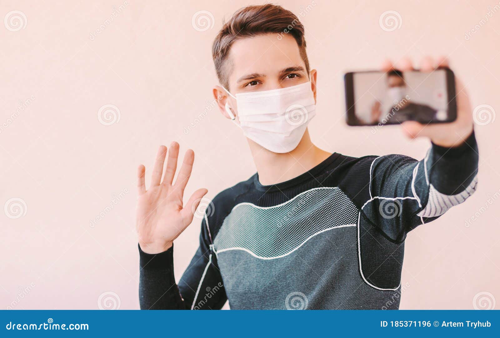 Happy Sports Man Waving Hand To Phone Camera while Streaming Online Video Stock Photo