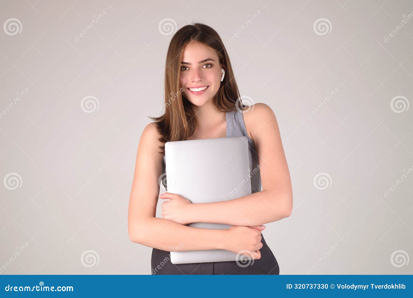 happy student. woman student in white t-shirt holding laptop and laptop,  over gray background. student posing