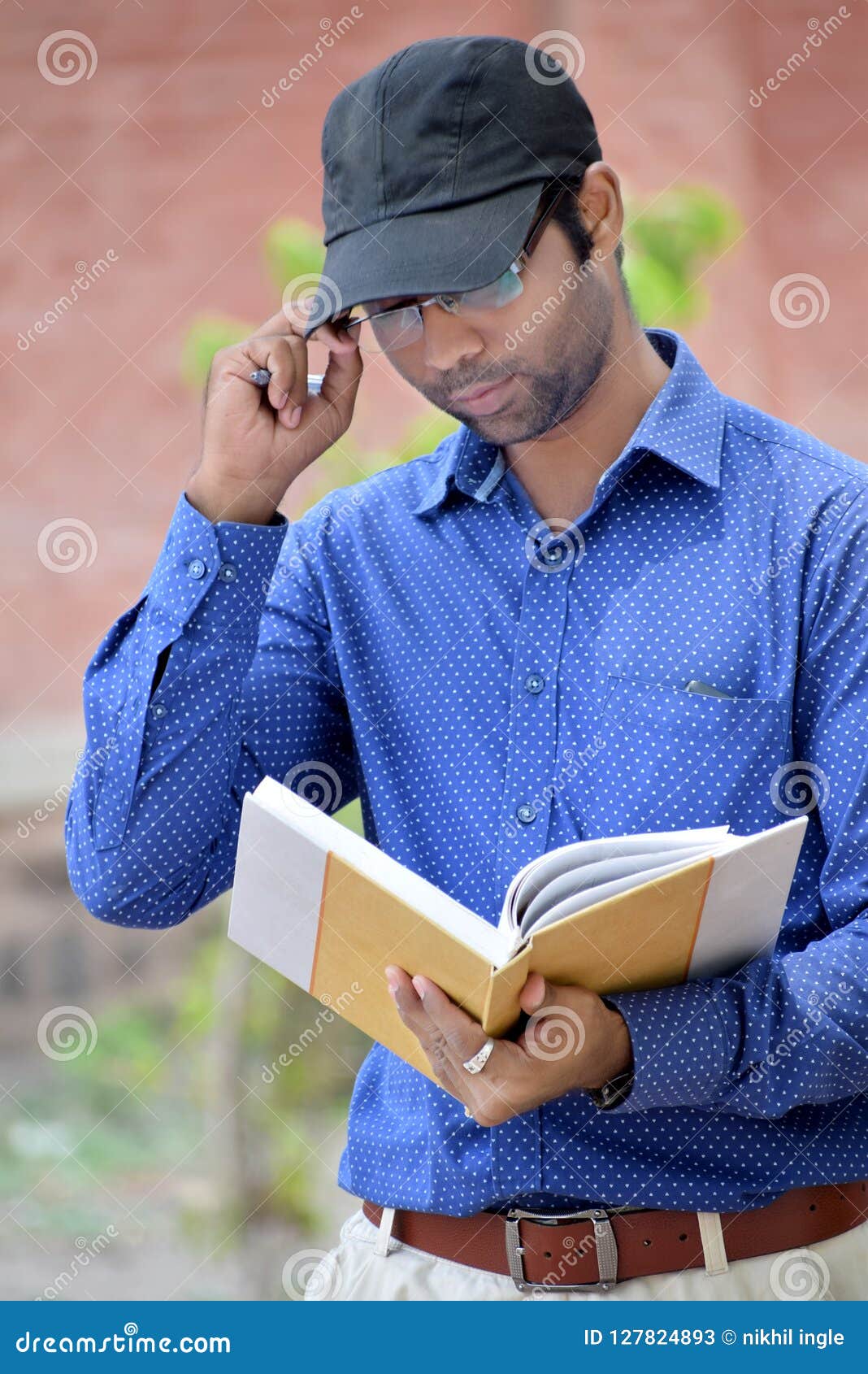 Happy Stylish Young Man Reading Book In The Park Stock