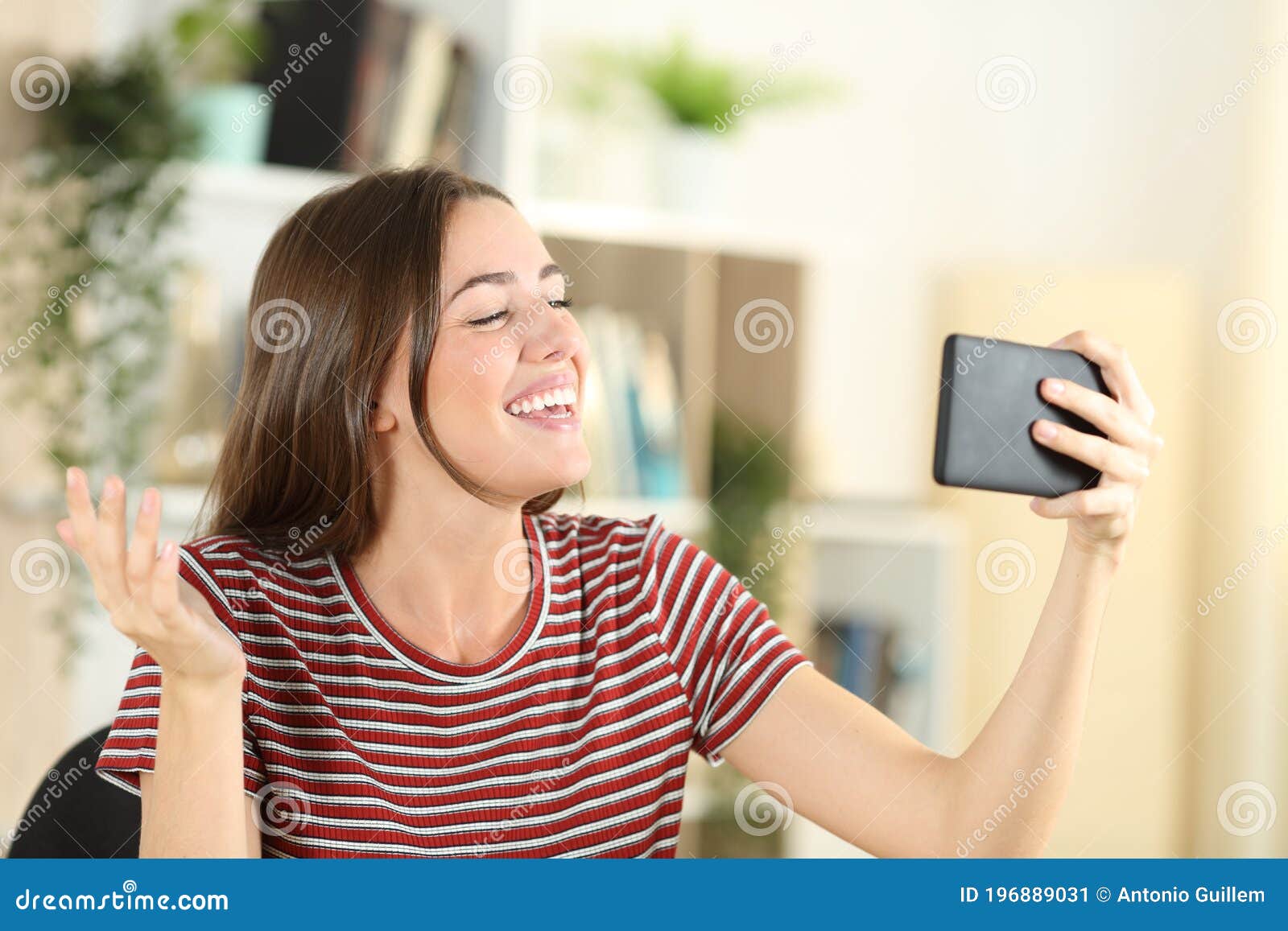 Happy Teen Talking in a Video Call on Phone at Home Stock Image - Image