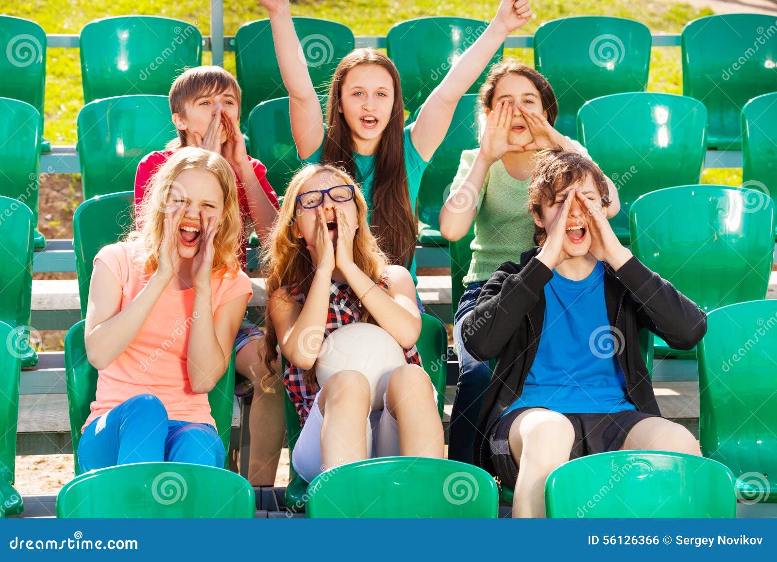 happy teenagers cheer for the team during game