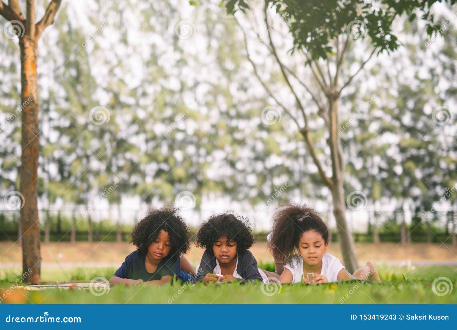 Tilslutte Professor Kig forbi Happy Three Little Friends Laying on the Grass in the Park. American African  Children Playing Toy in Park. Stock Image - Image of diverse, african:  153419243