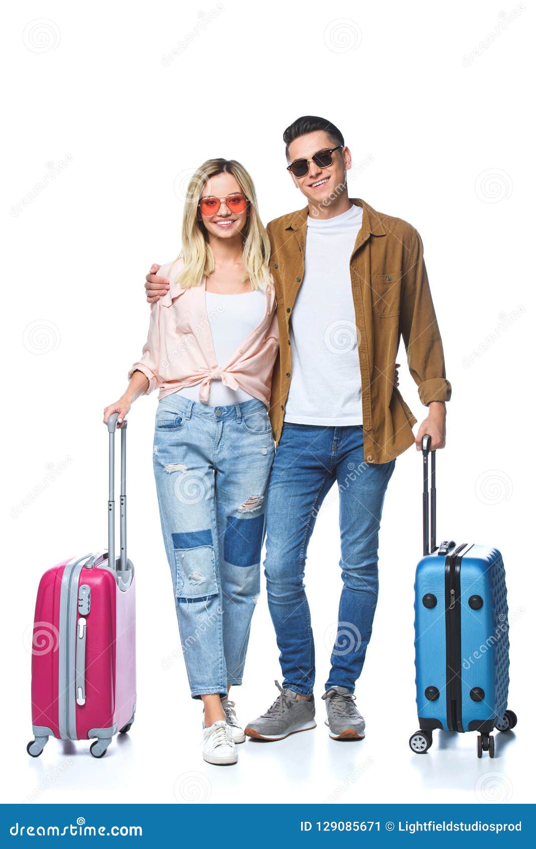 happy travelling couple with suitcases looking at camera