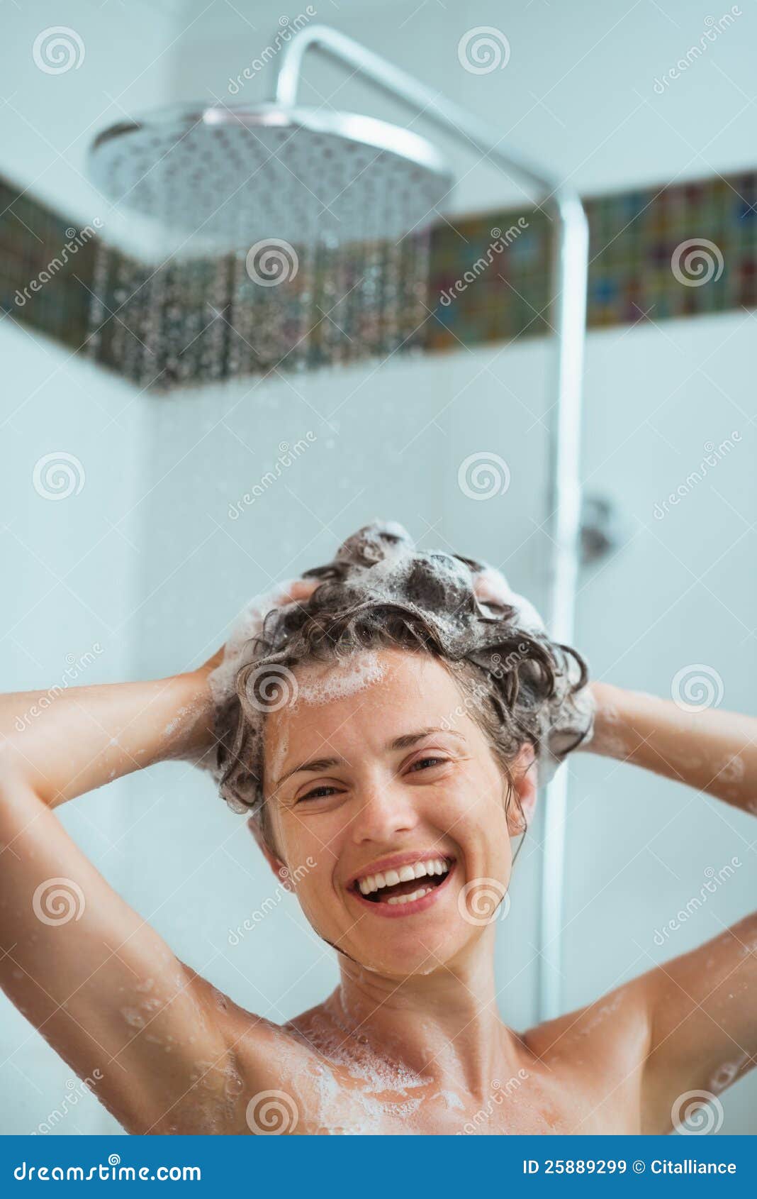 happy woman applying shampoo in shower