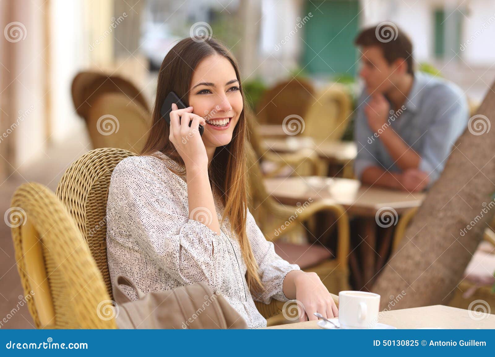 happy woman calling on the phone in a restaurant