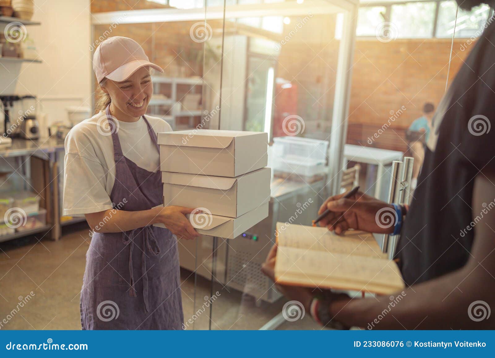 happy woman in cap holding food boxes