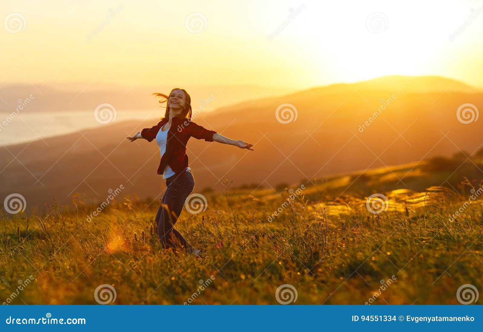 happy woman dances, rejoices, laughs on sunset in nature