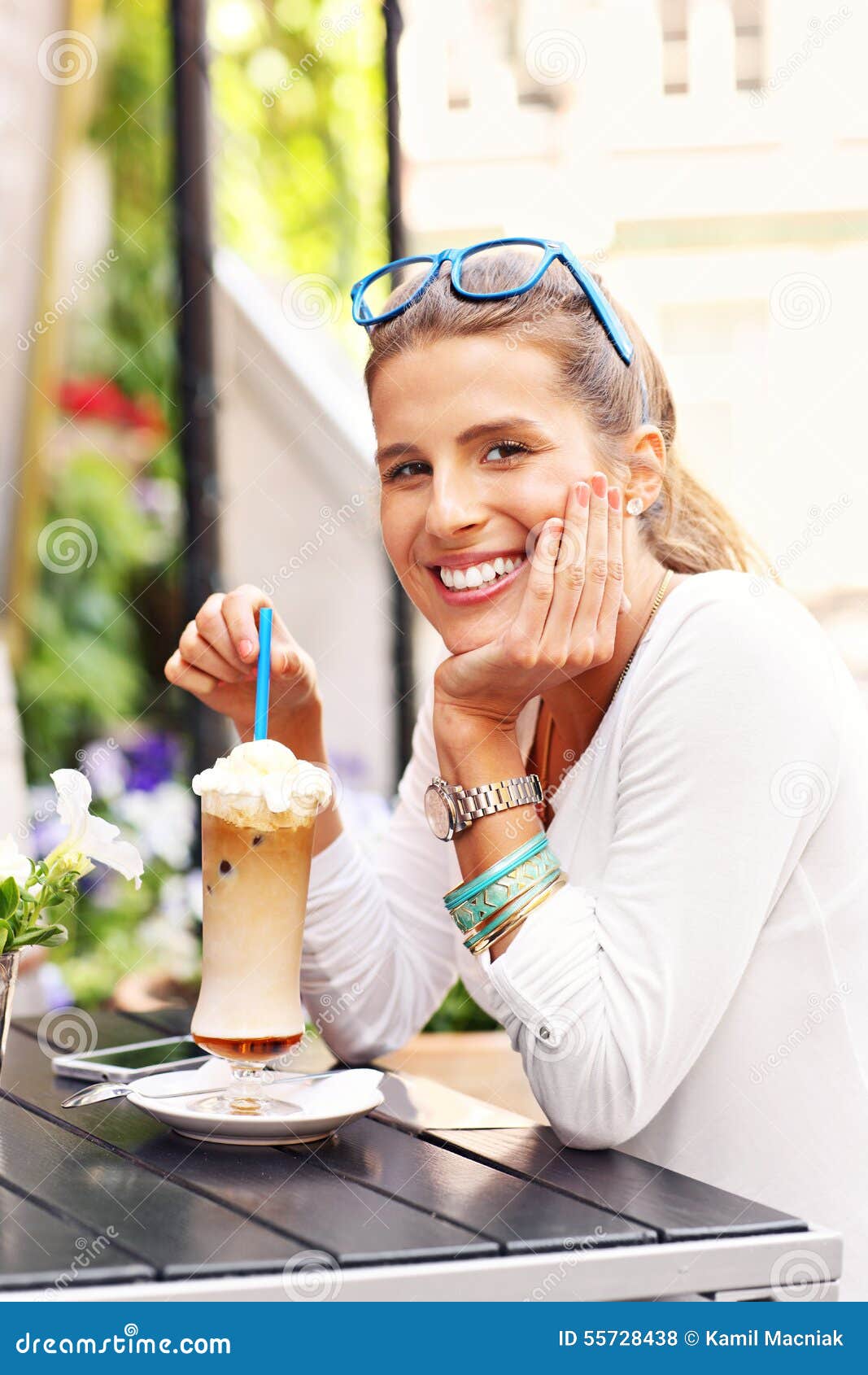 happy woman drinking frappe in cafe