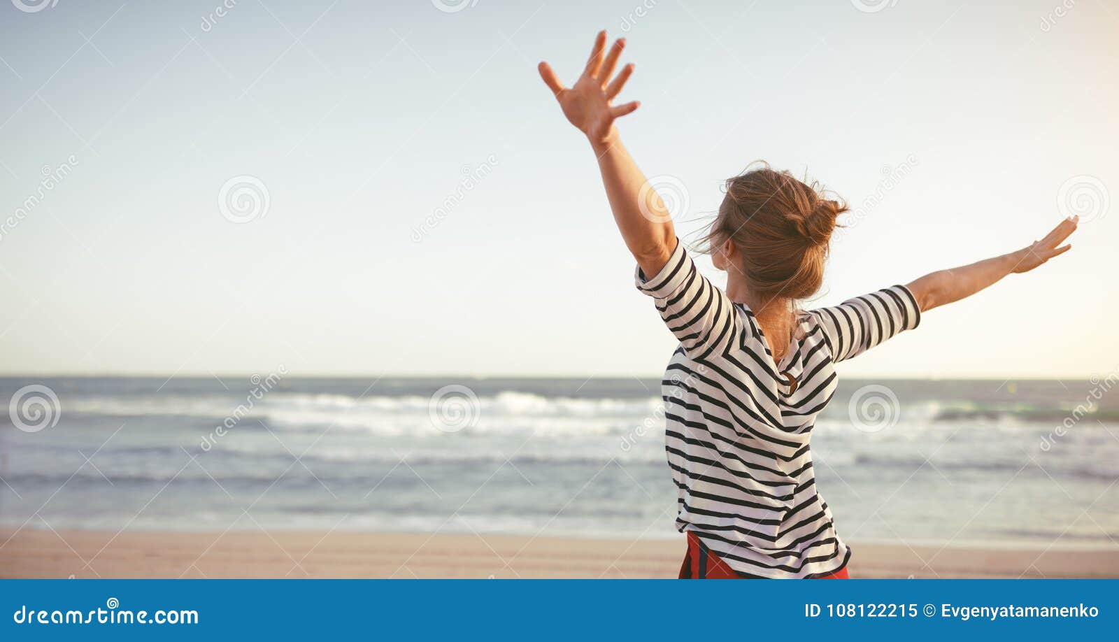 happy woman enjoying freedom with open hands on sea