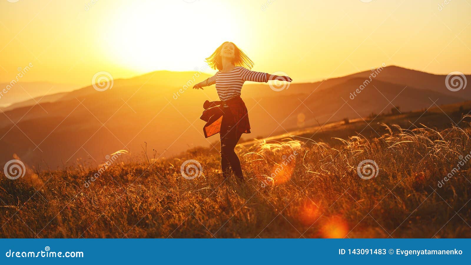 happy woman jumping and enjoying life  at sunset in mountains