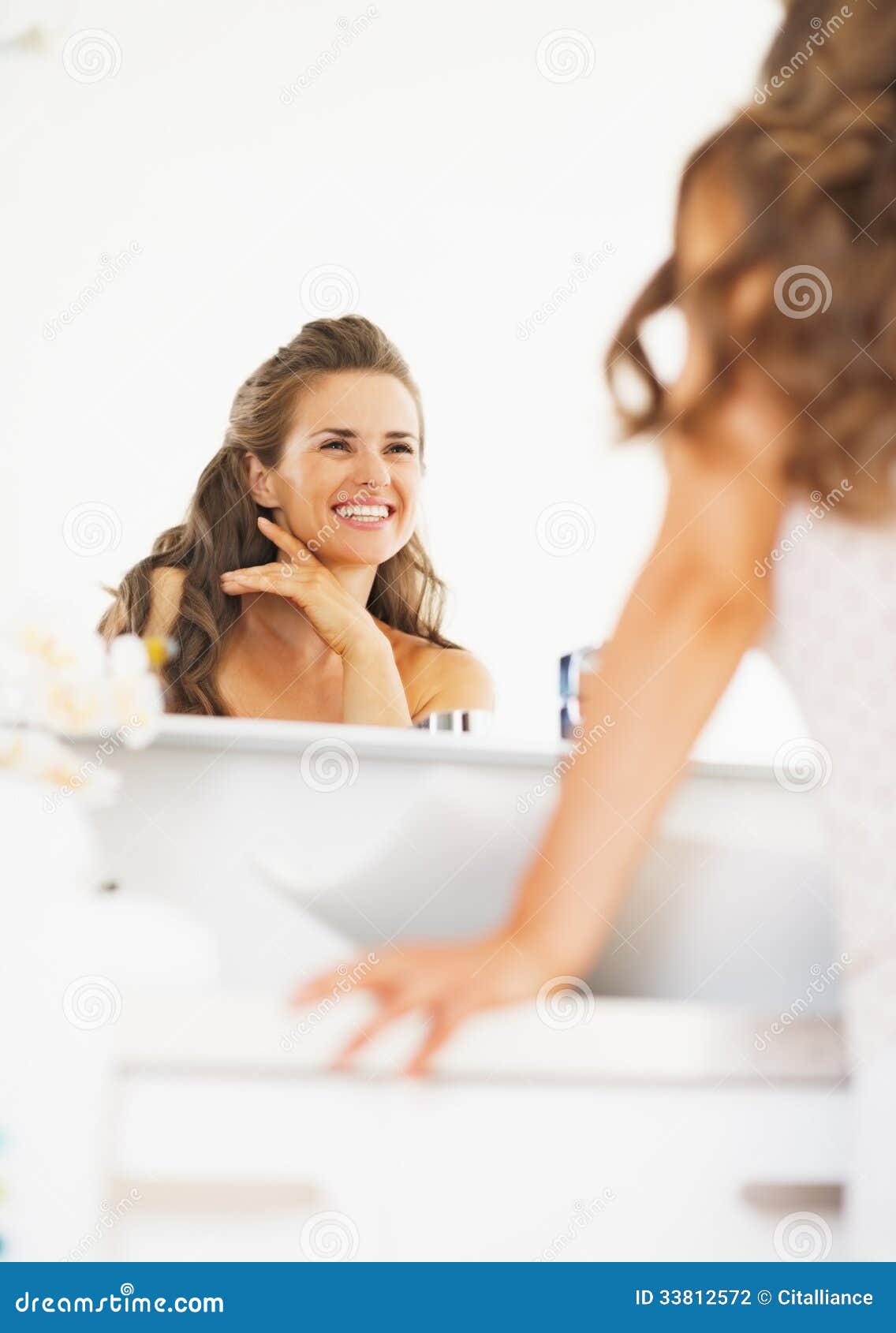 Happy Woman Looking In Mirror In Bathroom Stock Photo ...
