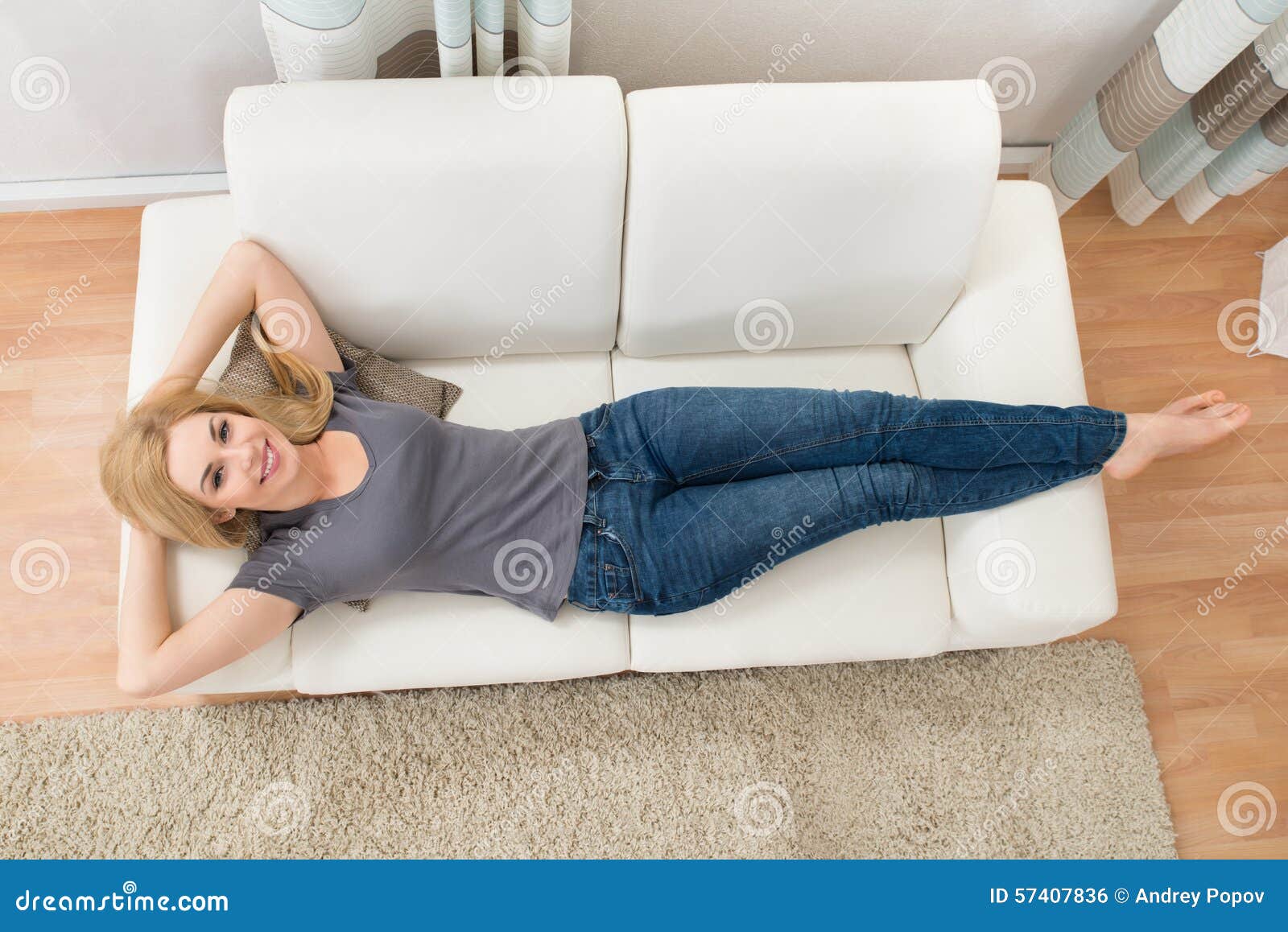 happy woman lying on sofa