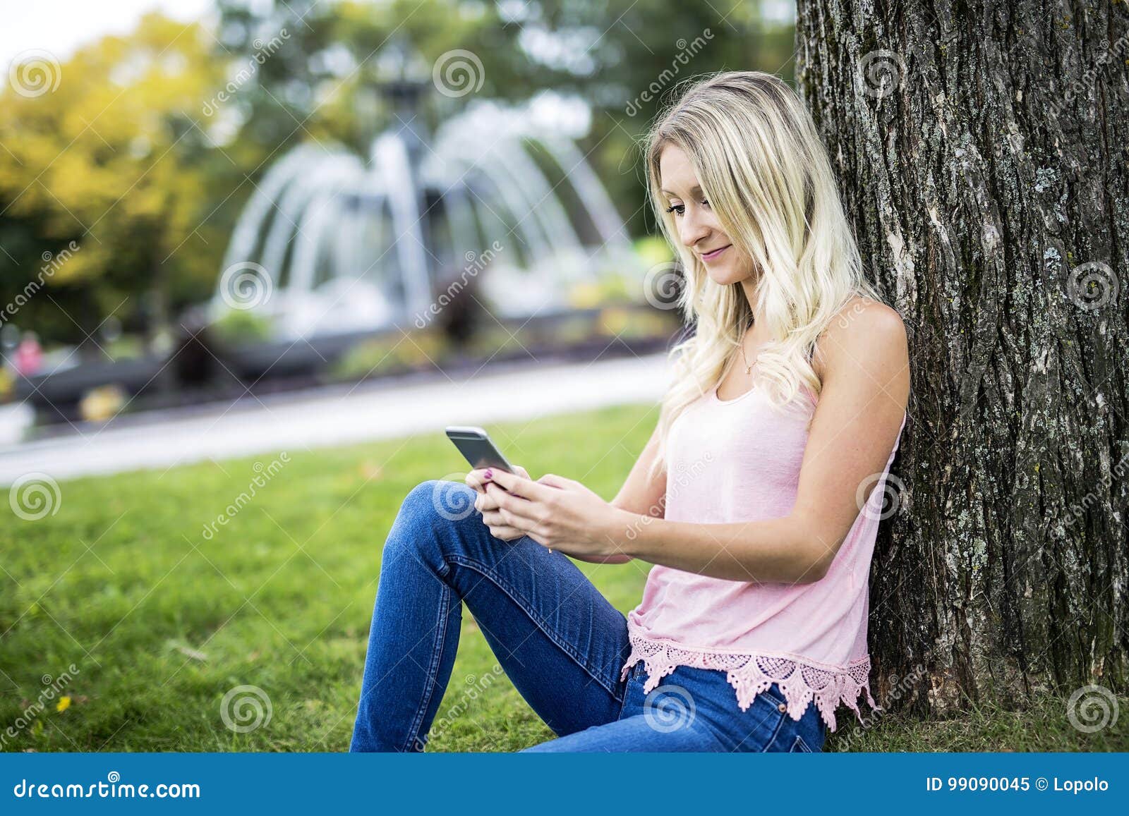 happy woman posing against a tree