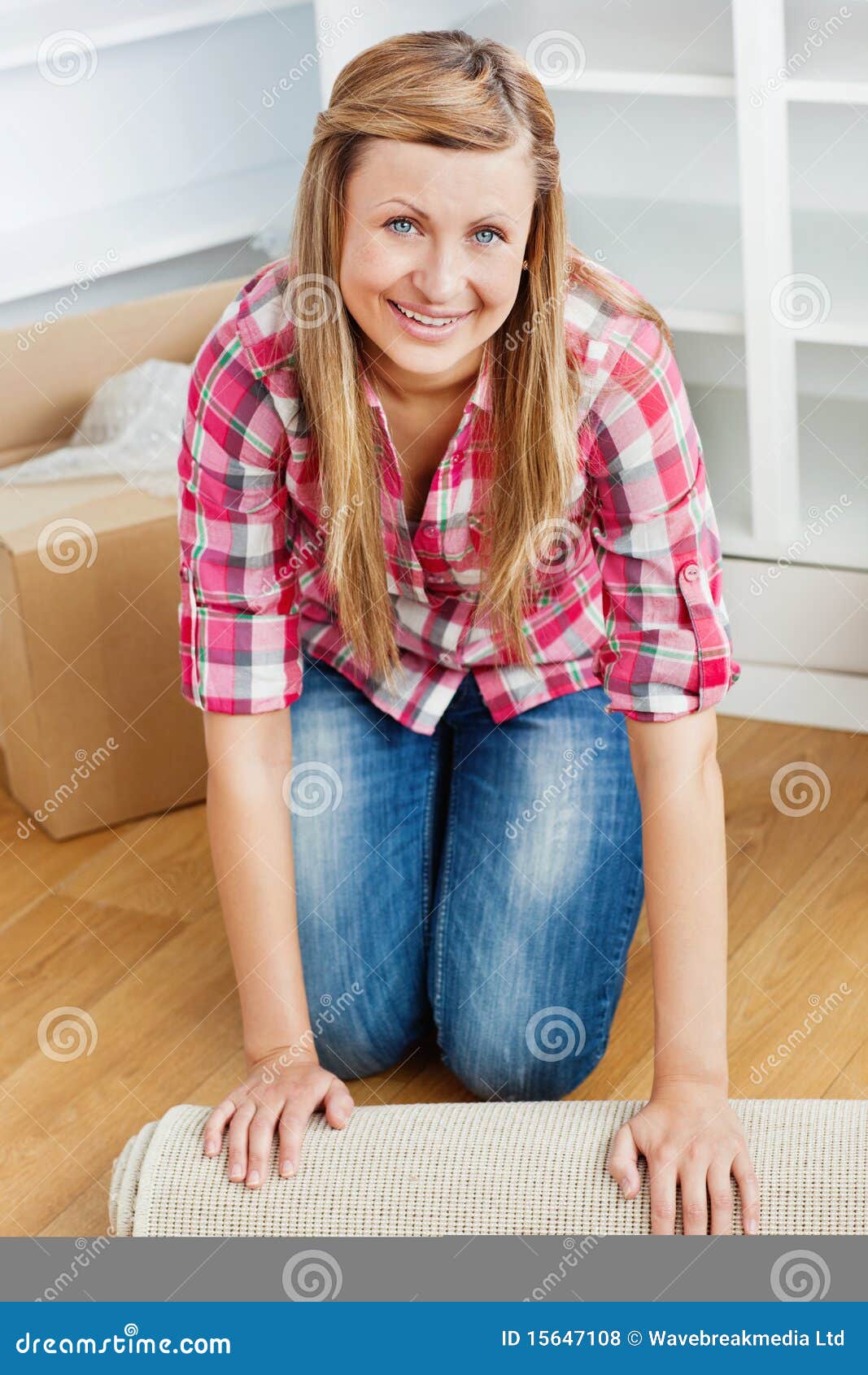 Happy Woman Rolling a Carpet Out Stock Photo - Image of happy, adult ...