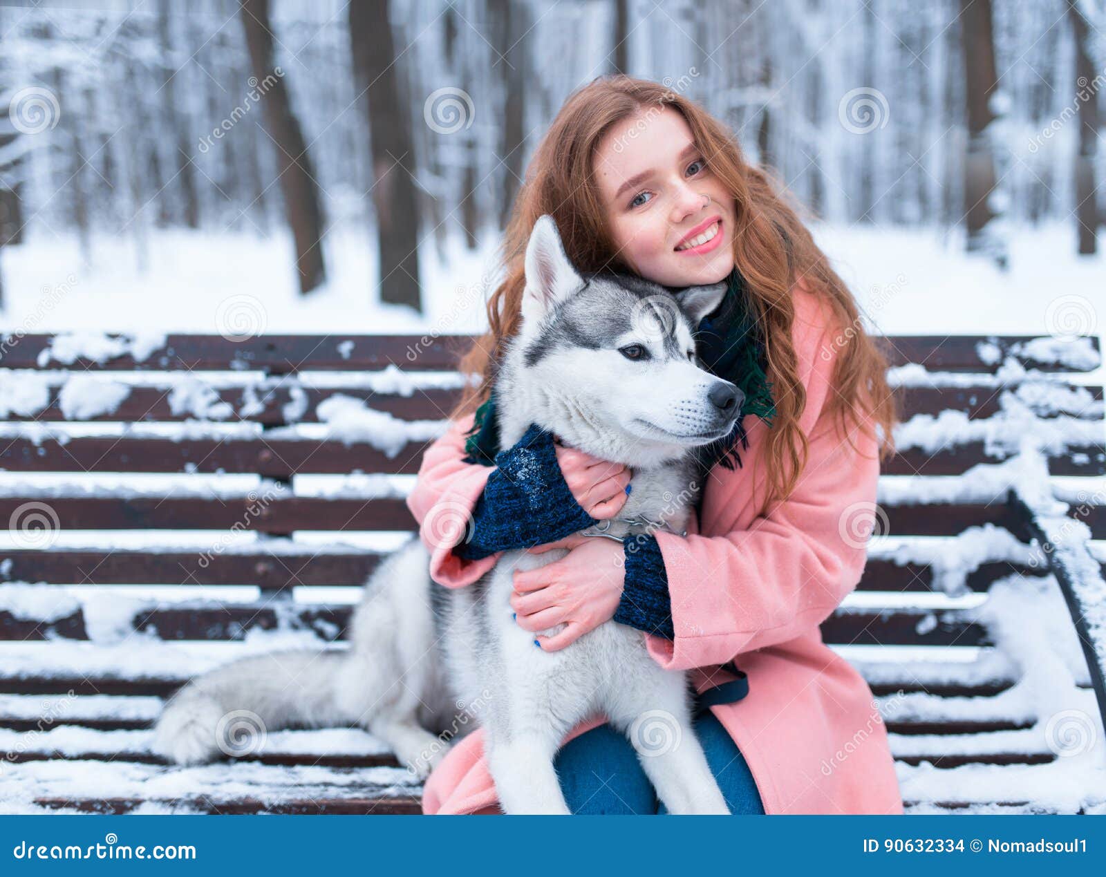 Happy woman sitting on the bench with husky. Happy woman sitting on the bench with siberian husky, snowy forest on background. Cute girl hugs with charming dog. Real friendship with pet