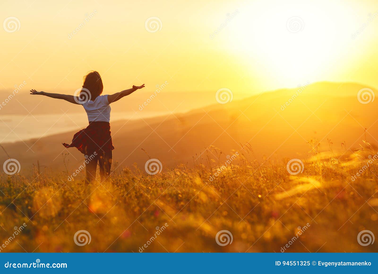 happy woman standing with her back on sunset in nature iwith ope