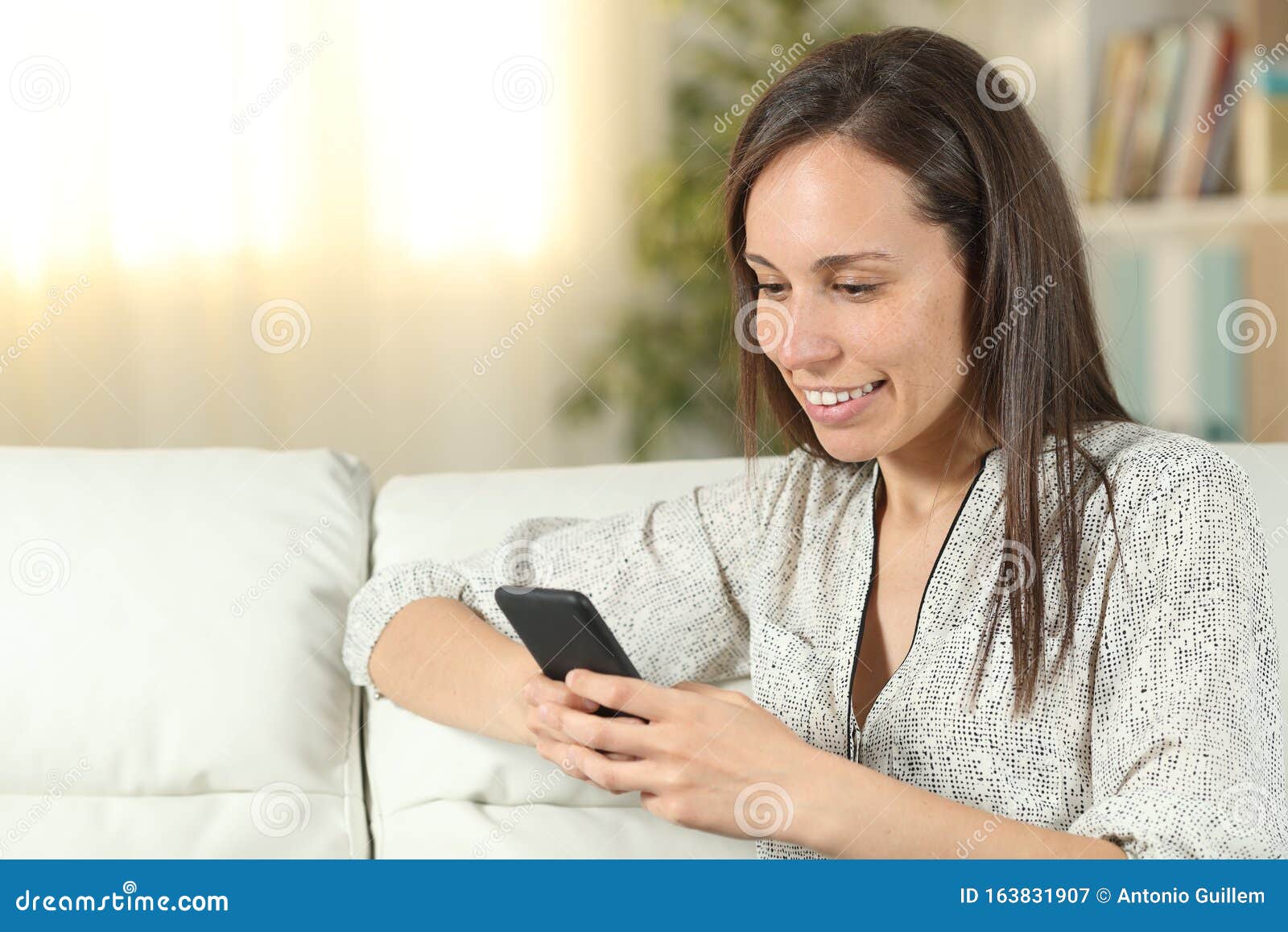 Happy Woman Uses Smart Phone On A Couch At Home Stock Image Image Of 